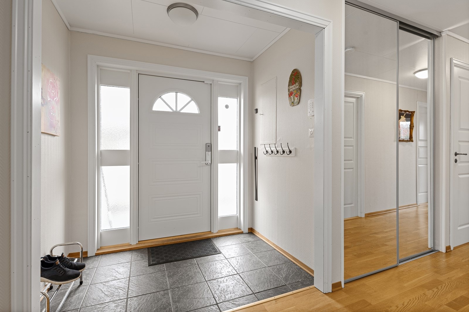 Lys og romslig entré med kjekk oppbevaringsplass til ytterklær Galleribilde