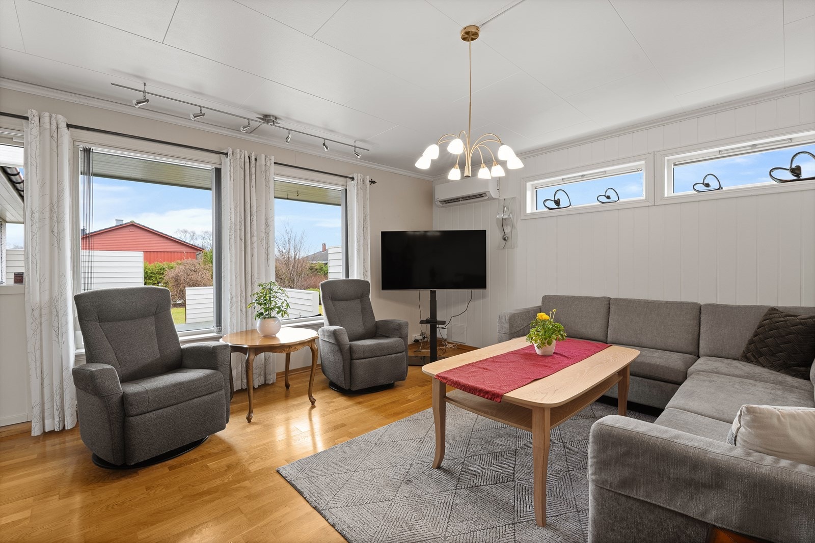 Koselig sofakrok med store vinduer som gir rikelig med dagslys Galleribilde