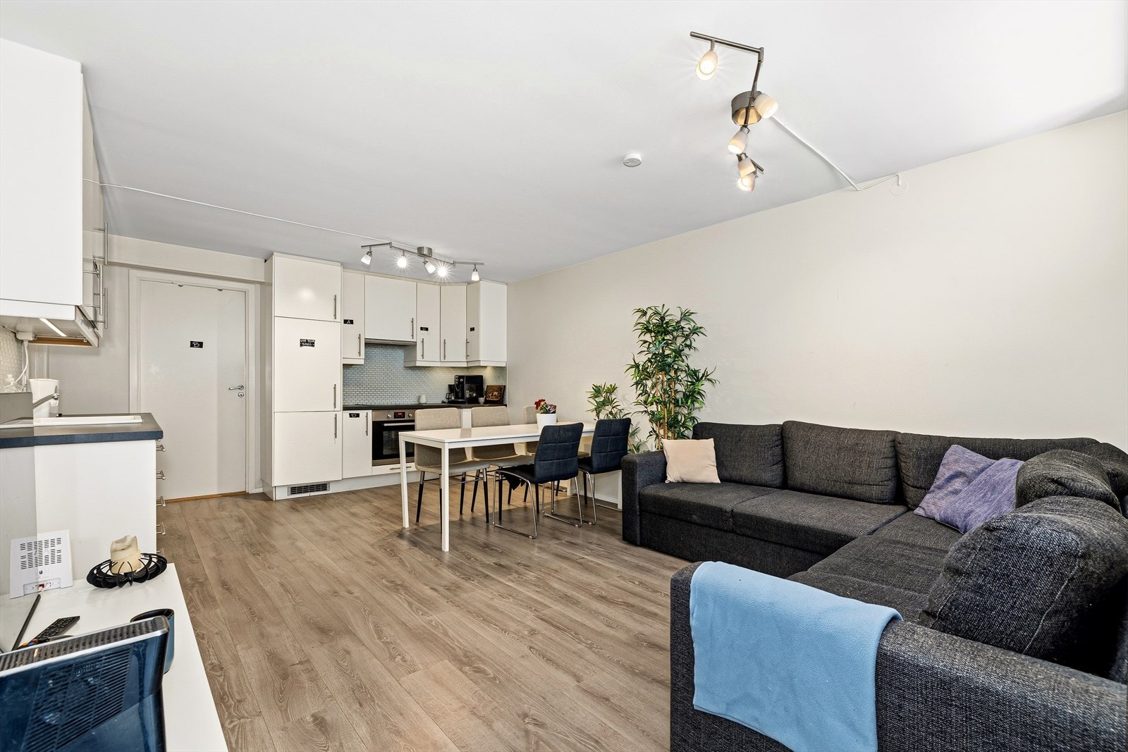 Leiligheten har en åpen stue og kjøkkenløsning med integrerte hvitevarer. Galleribilde