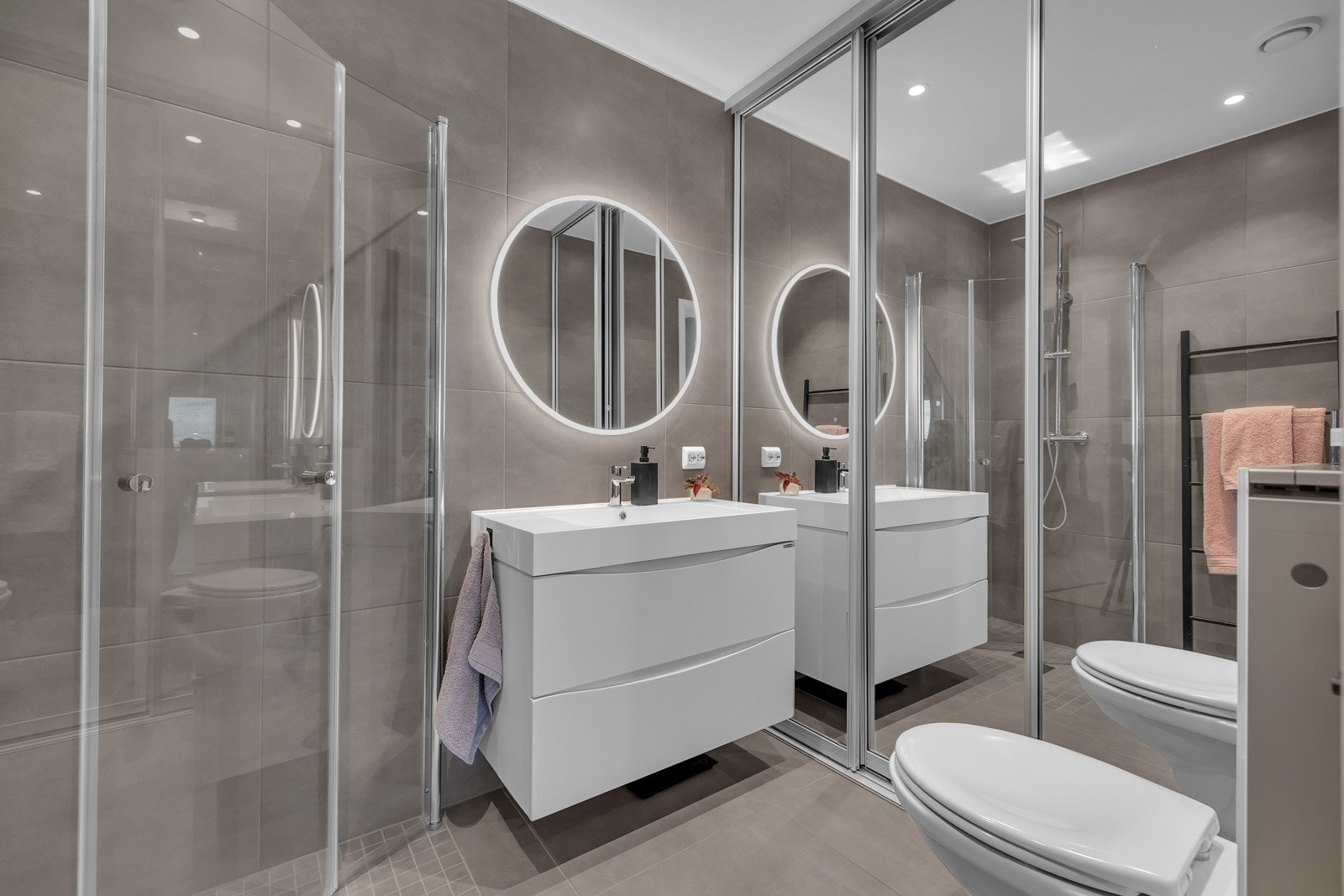 Innfellbare glassdører i dusjsonen, innredning med heldekkende servant og god lagring i kolonialskuffer Galleribilde