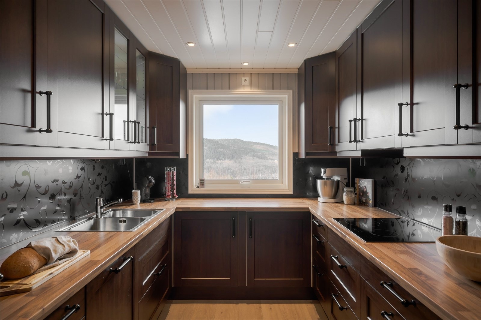 Kjøkkeninnredning i u-form er praktisk og gir kort vei mellom de ulike arbeidssonene. Godt lysinslipp Galleribilde