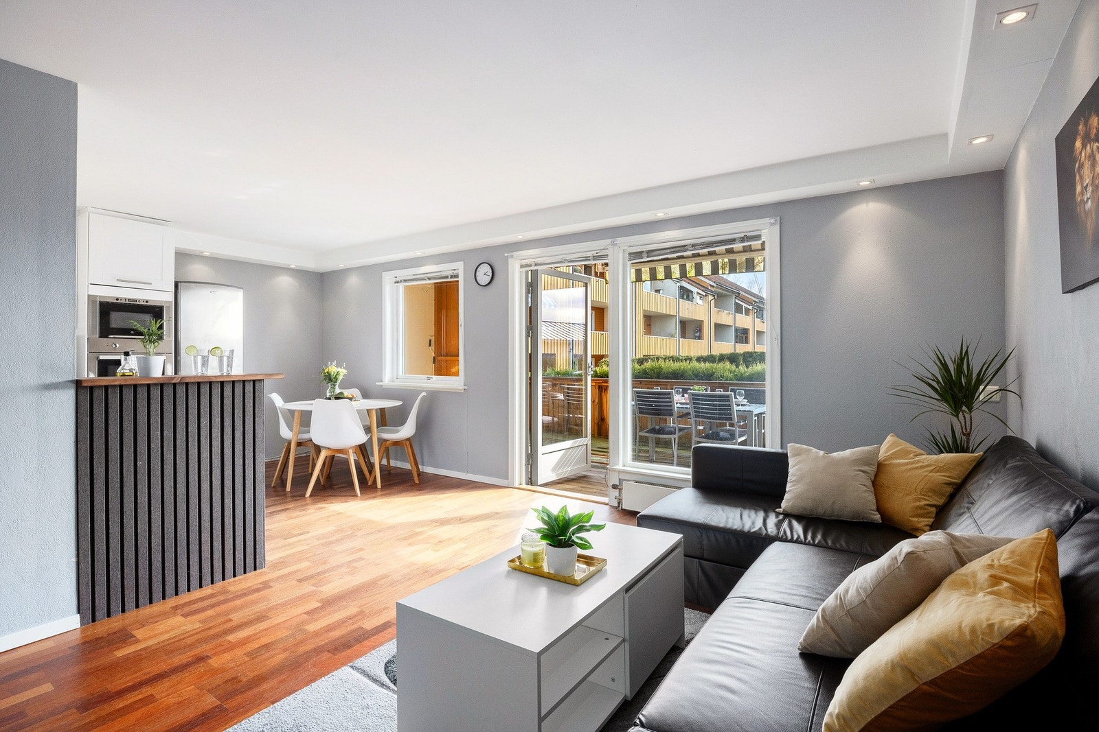 Dette er en lys og romslig stue med parkett på gulv, nøytrale veggfarger og downlights i tak som gir et moderne preg. Galleribilde