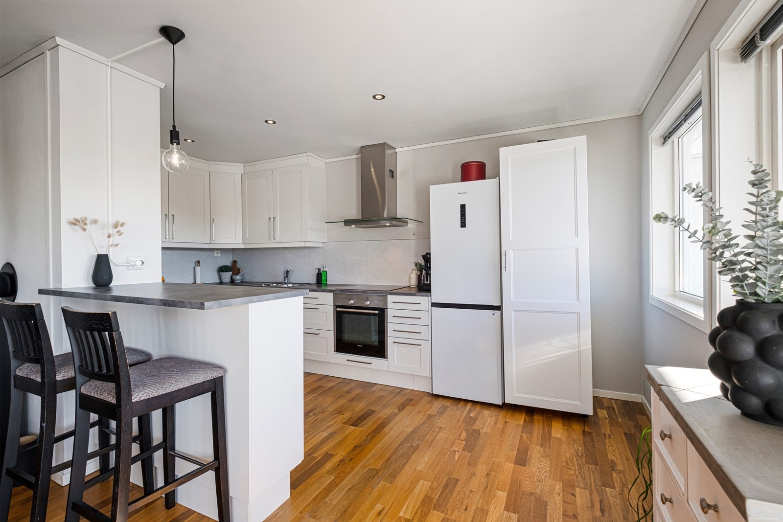 Kjøkkenet har hvite, takhøye fronter og laminat benkeplate. Galleribilde