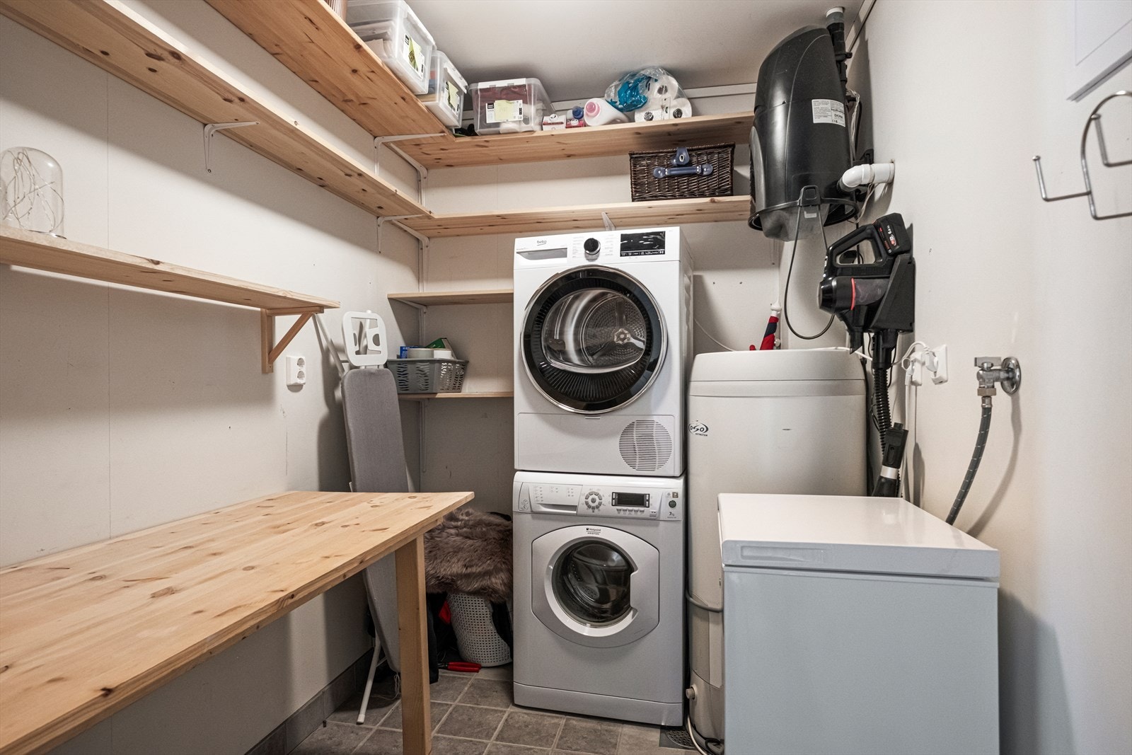 Vaskerom med flislagt gulv og opplegg for vaskemaskin. Rommet er godkjent som bod, og endringen fra bod til vaskerom er ikke omsøkt/godkjent. Galleribilde