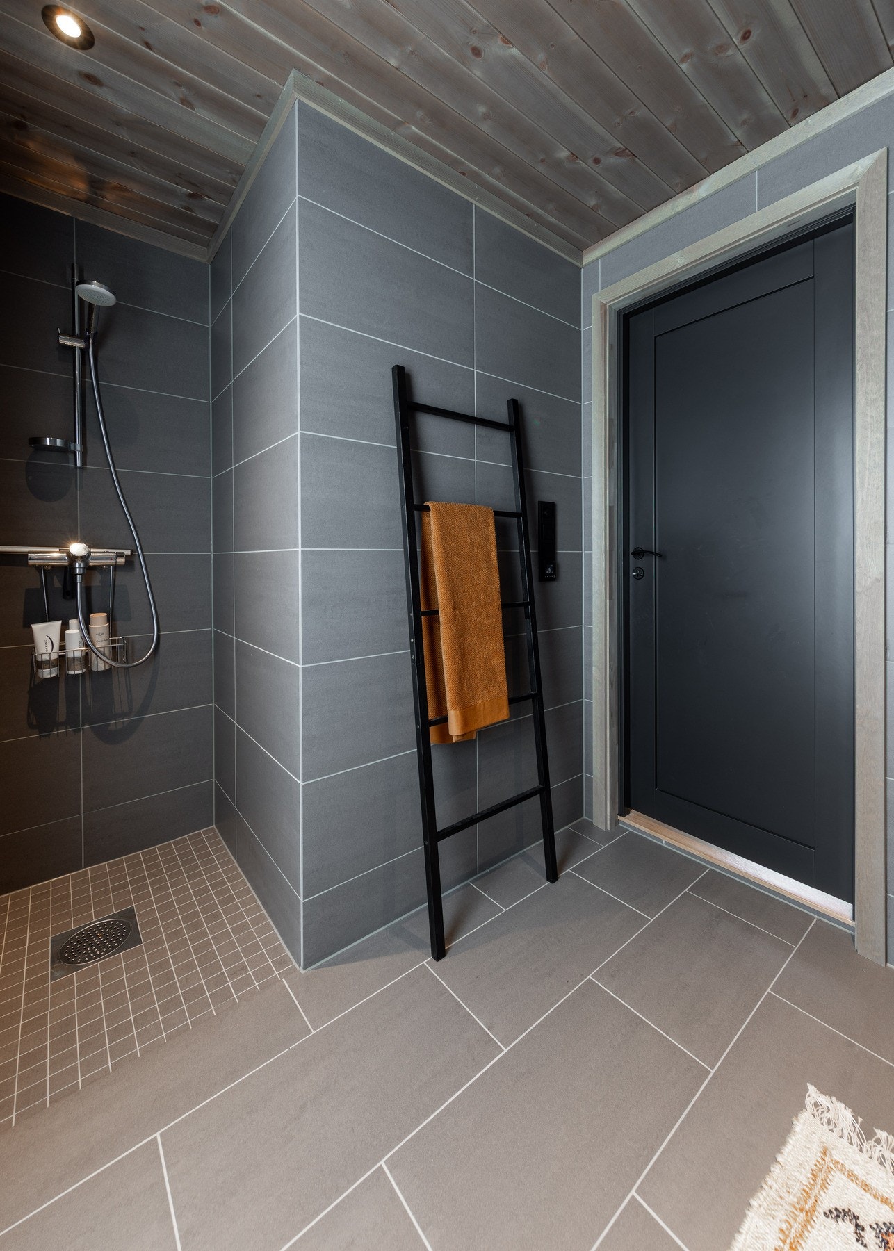 Badet inneholder vegghengt servantinnredning med heldekkende servanttopp, speil med integrert belysning, vegghengt toalett og innfelt dusjnisje Galleribilde