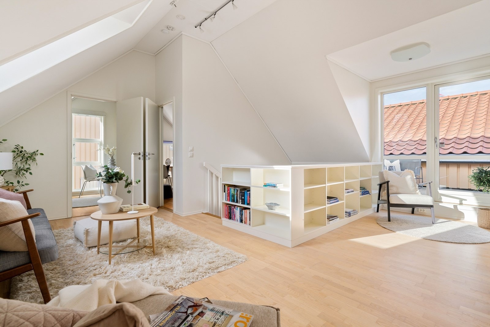 Oppholdsrommet er innredet med plassbygde bokhyller og har direkte adkomst til en romslig og solrik takterrasse. Galleribilde