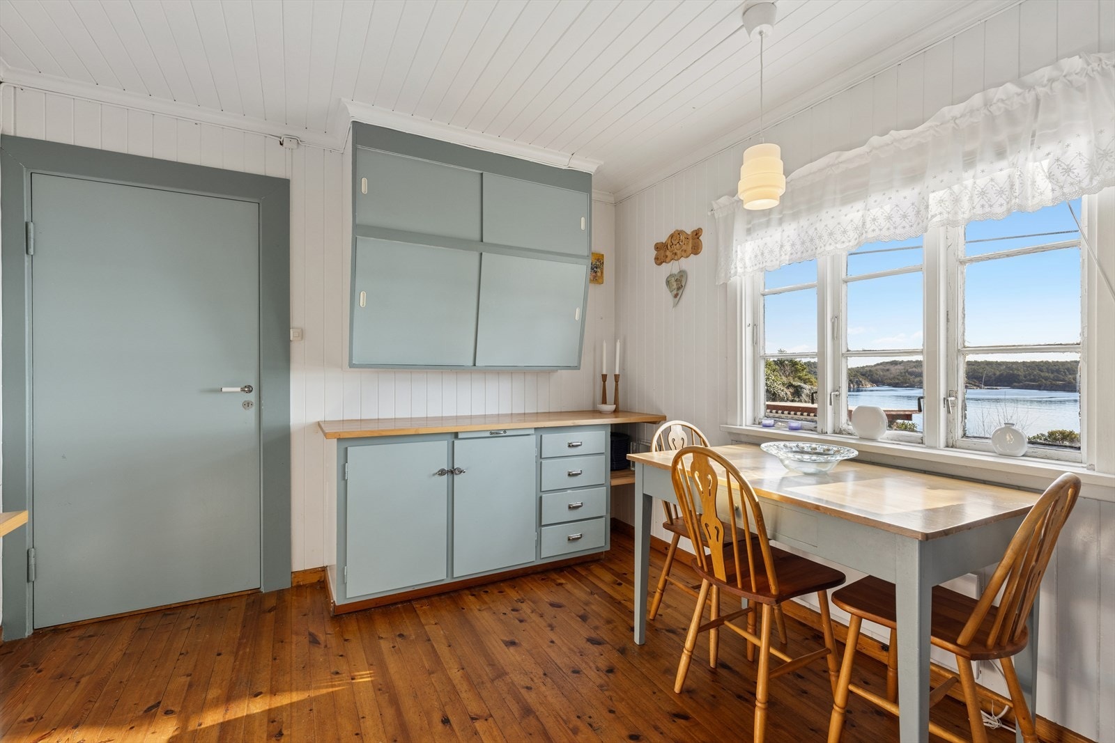 Kjøkkenet er av eldre dato med malte fronter og heltre benkeplate. Det er plass for frittstående komfyr og kjøleskap. Galleribilde