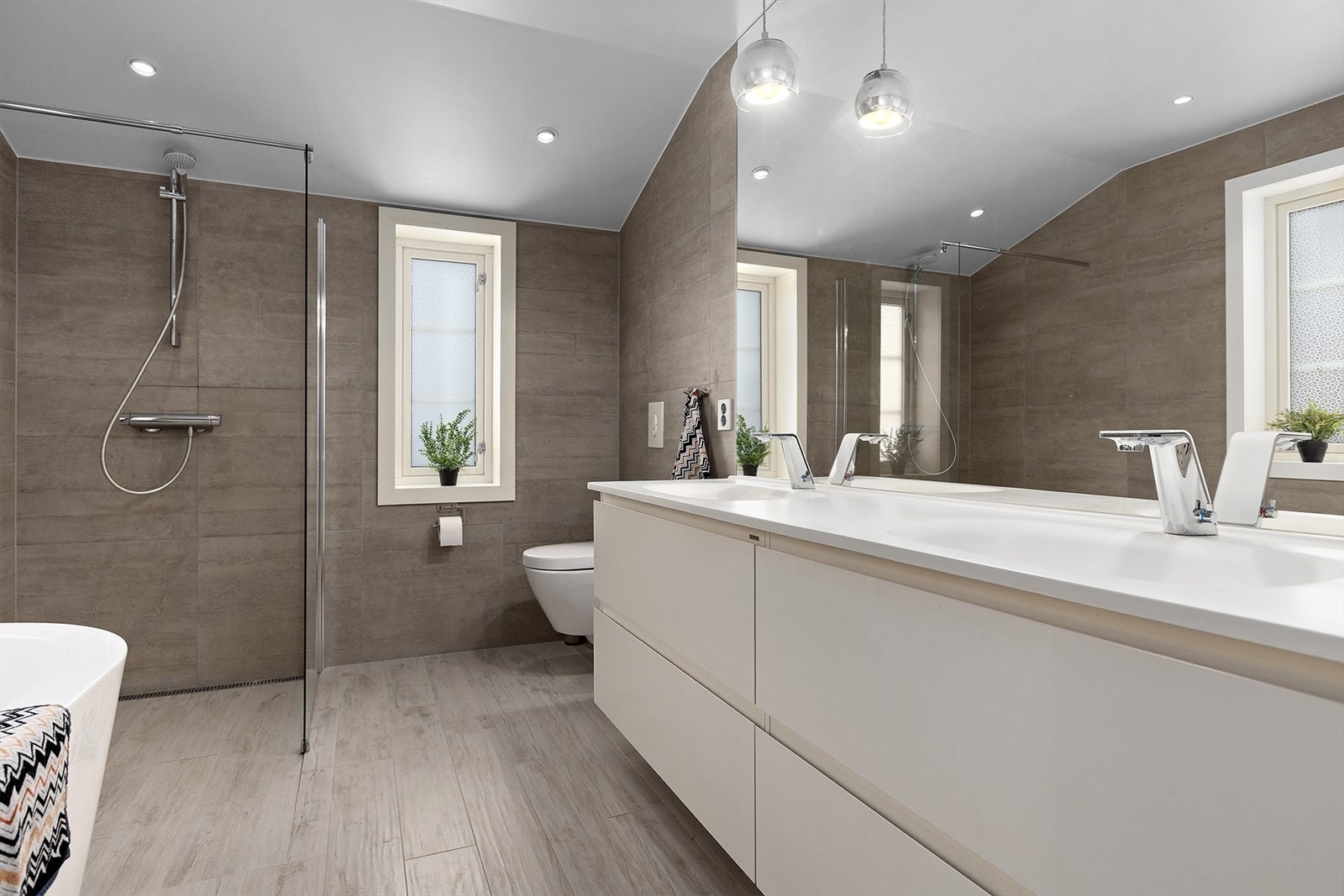 Svært moderne bad med lys innredning og god skuffeplass under 2 servanter Galleribilde