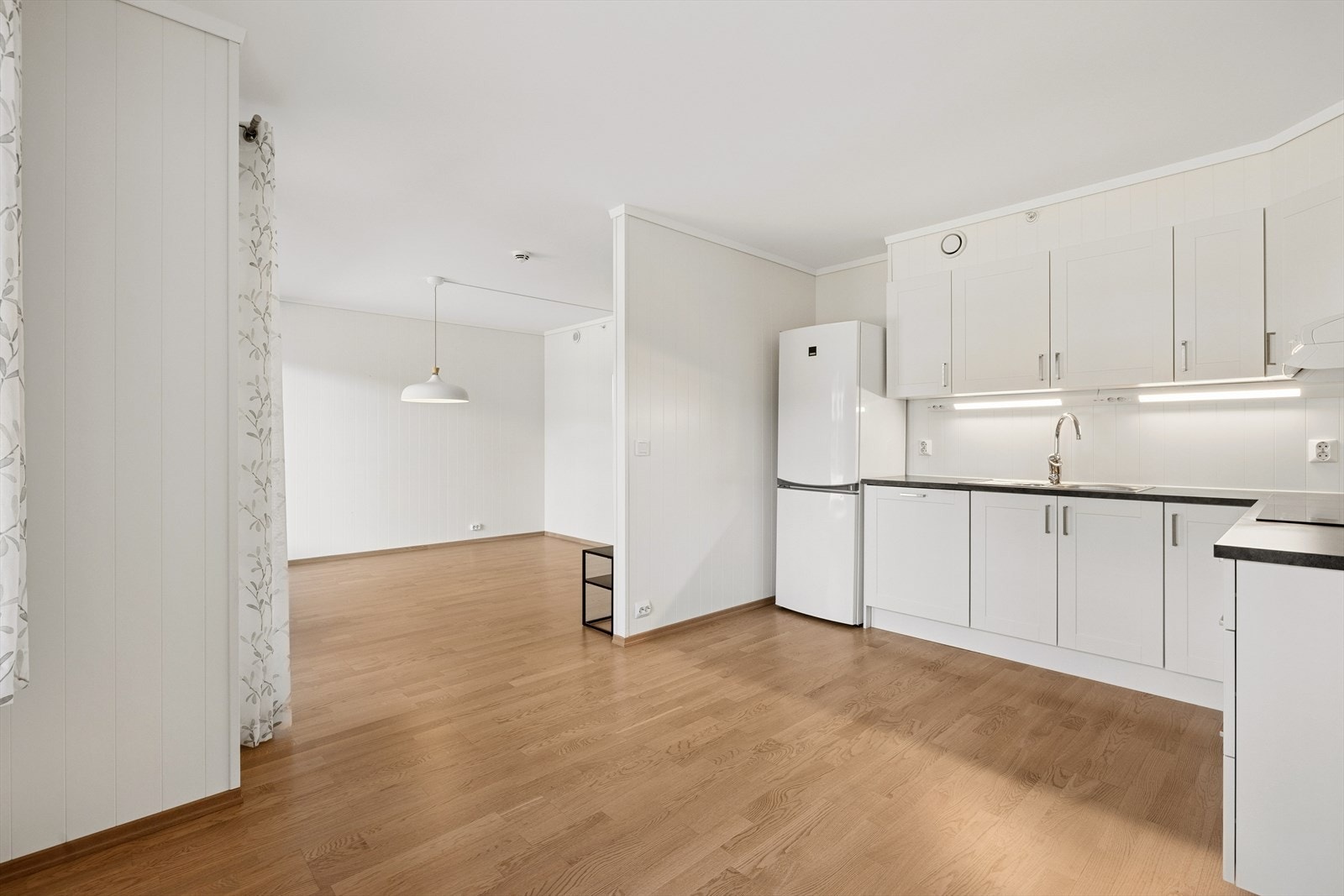 Delvis åpen stue og kjøkkenløsning, samtidig pent adskilt med praktisk halvvegg. Galleribilde