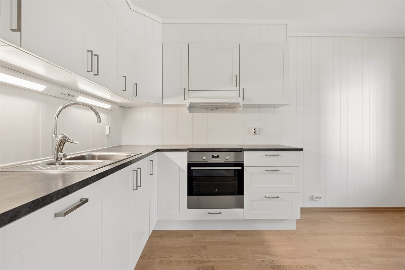 Kjøkkenet har integrerte hvitevarer som stekeovn, platetopp, oppvaskmaskin og frittstående kjøleskap. Galleribilde