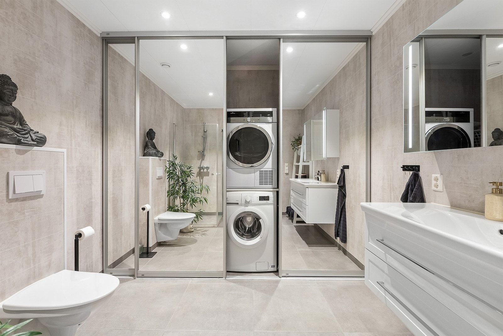 Badet har varme i gulv, hjørnedusj, innredning med skuffer, wc samt vaskeromsløsning bak skyvedør. Galleribilde