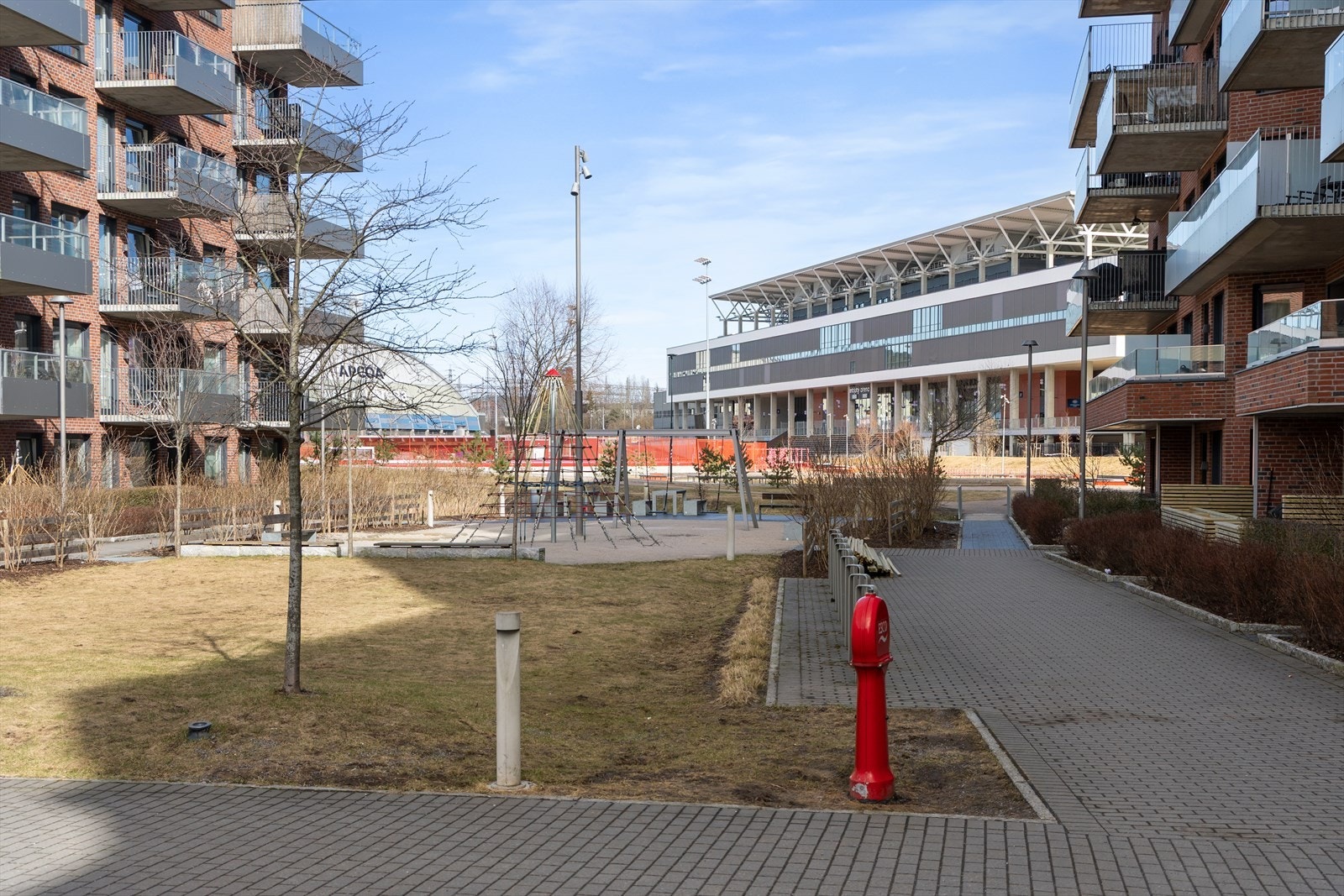 Tomten er pent opparbeidet med sykkelstativ, lekeapparater og diverse beplantning. Galleribilde