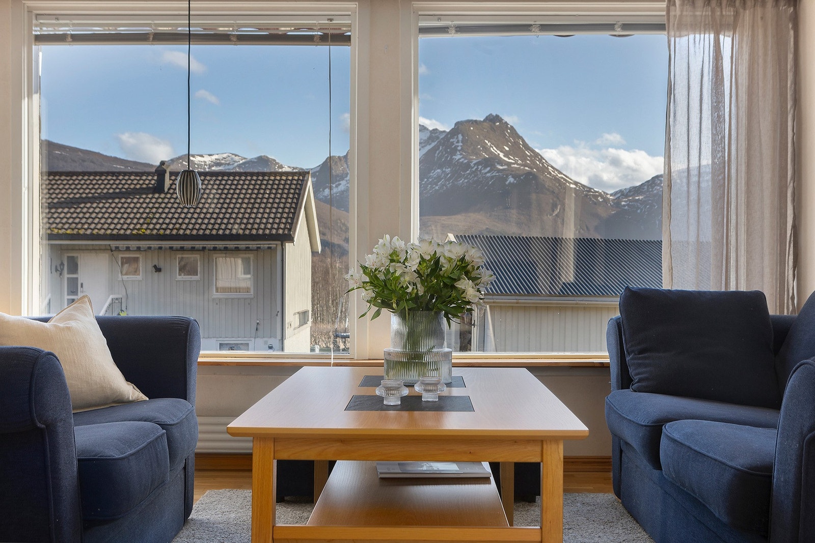 Stue med store vindusflater som slipper inn rikelig med naturlig lys og skaper en luftig og innbydende atmosfære. Galleribilde