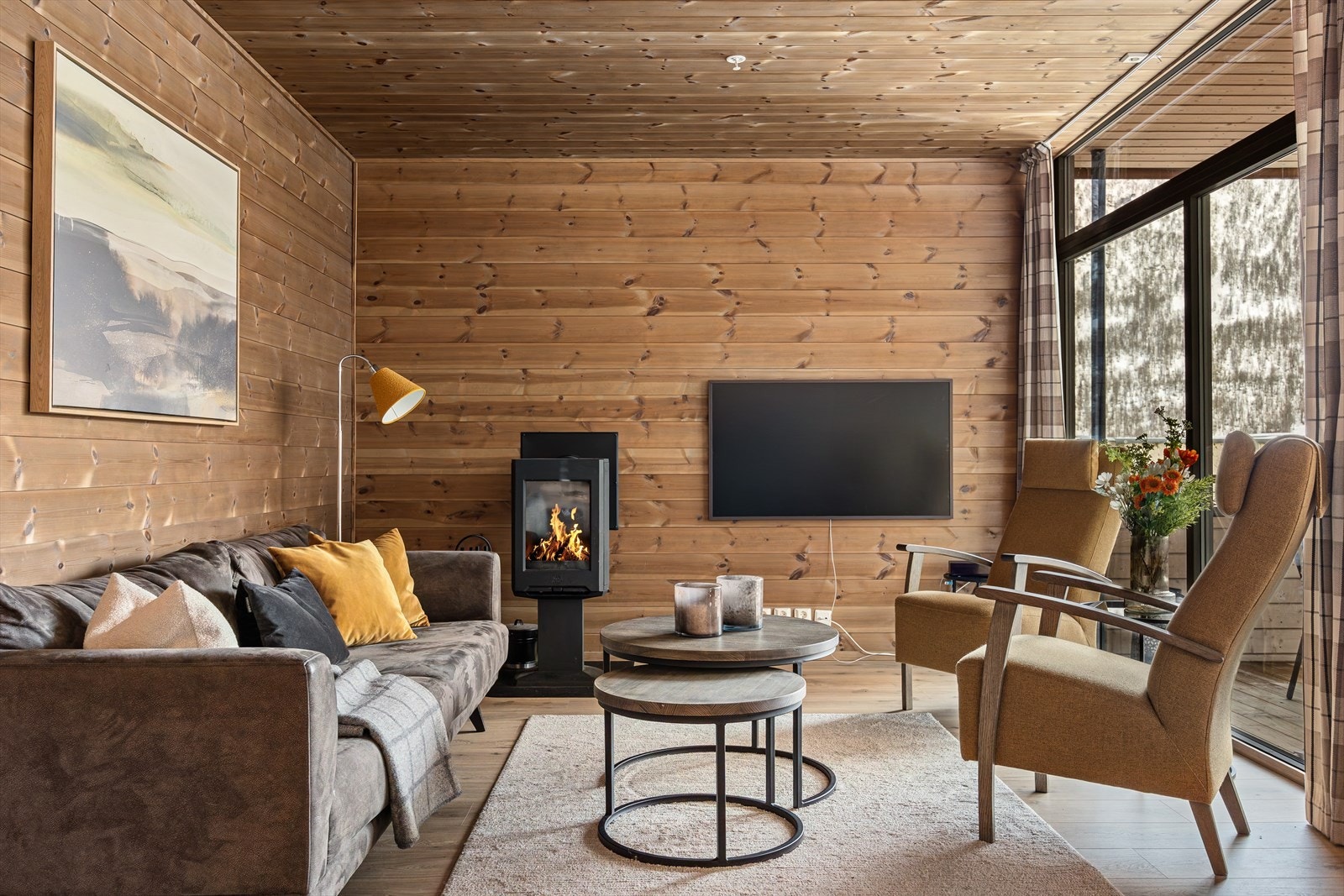 Her er det god plass til stor sofagruppe og peisen skaper en lun og ekte hyttefølelse Galleribilde
