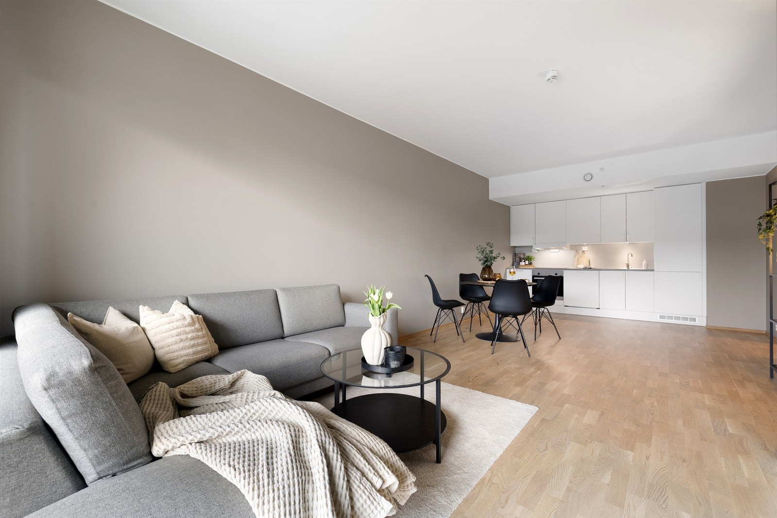 Tidsiktig farge på vegg og lys himling, kombinert med en moderne parkett på gulv, gir en behagelig atmosfære i leilighetens oppholdsareal. Galleribilde