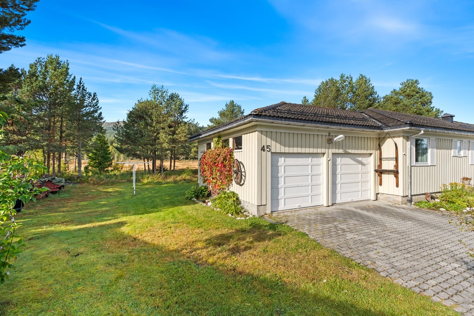 Vegg i vegg med boligen er det satt opp dobbeltgarasje på 40 m² med elektronisk styrte porter. Galleribilde