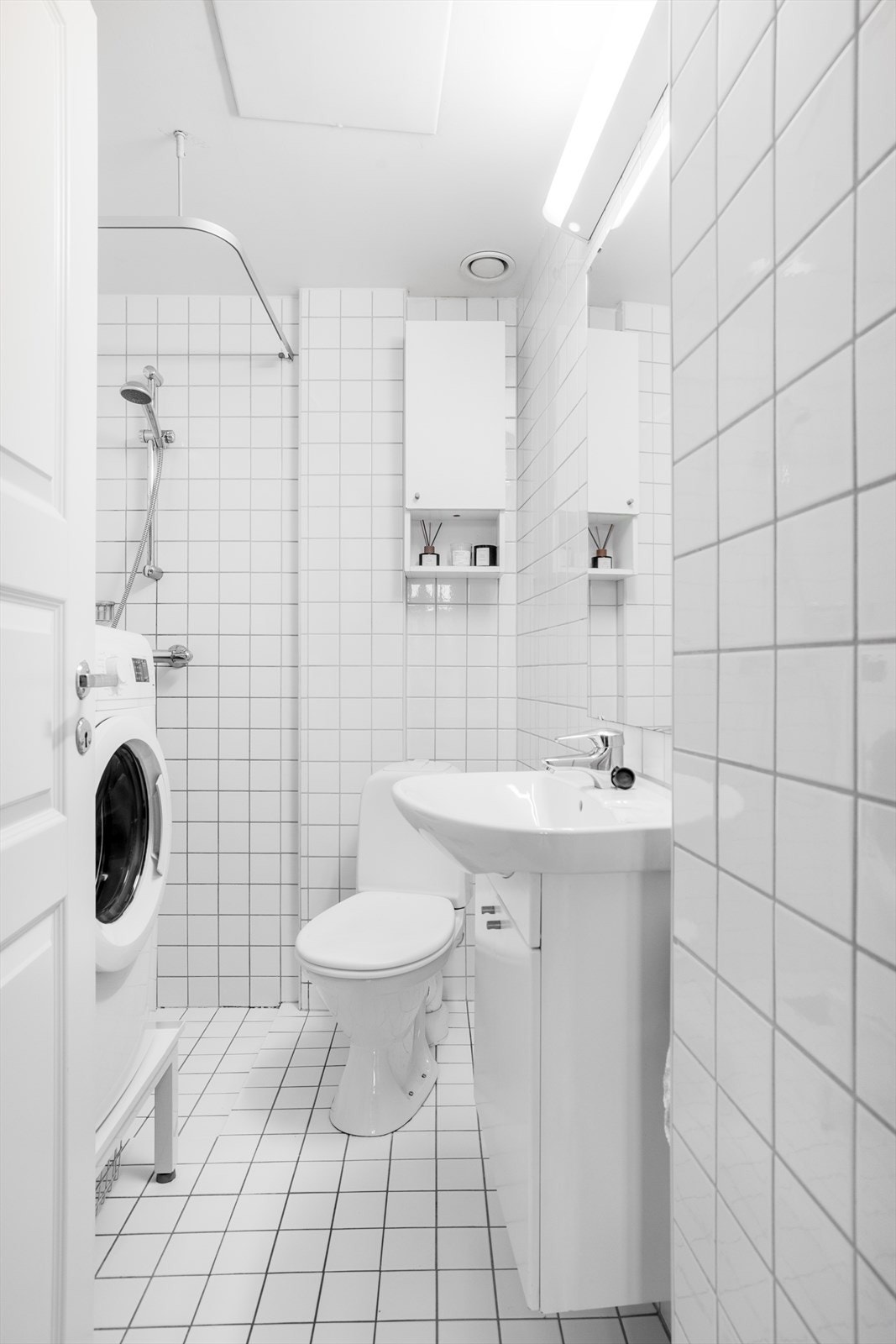 Praktisk bad med hvite fliser som gir et pent og tidsløst uttrykk Galleribilde