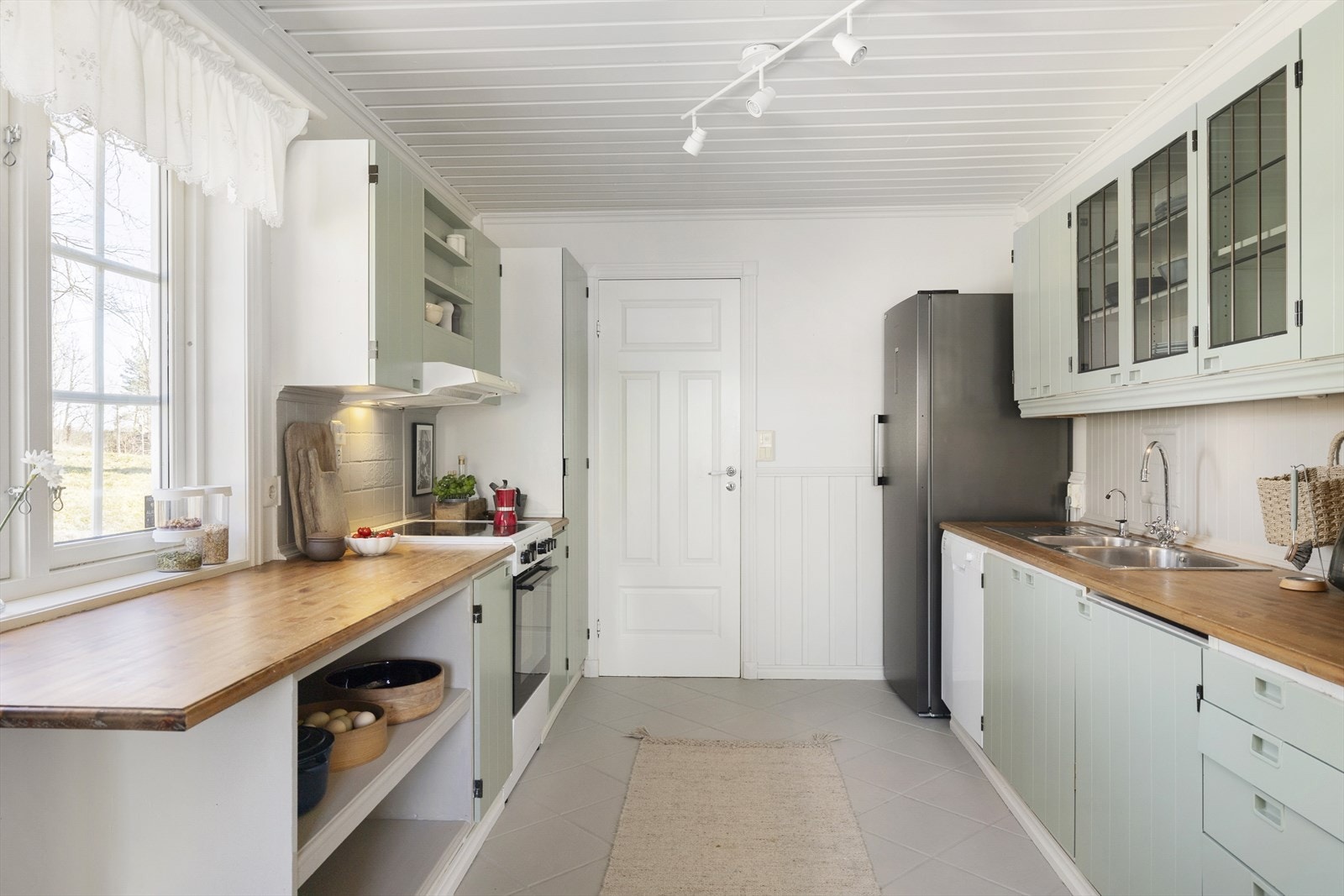 Stilen på kjøkkenet passer perfekt inn i denne landlige boligen med koselige eldre skap og hyller. Galleribilde