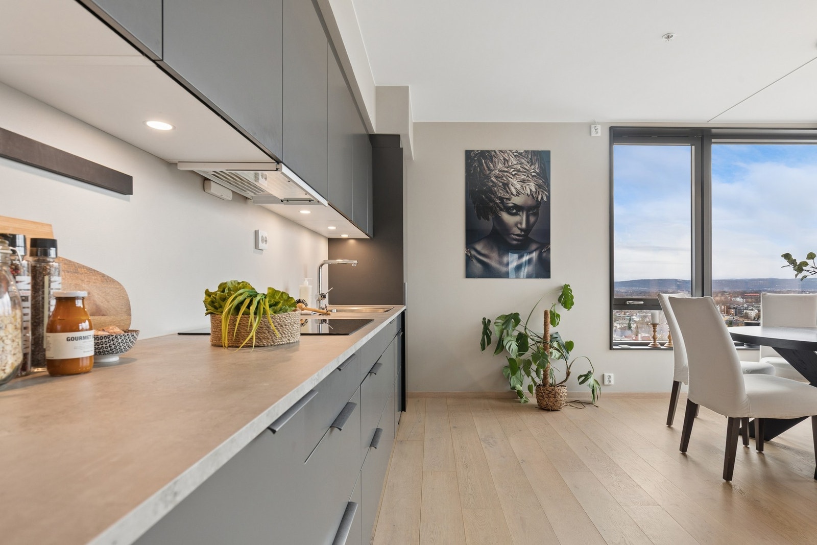 Kjøkkenet fremstår moderne med glatte fronter og integrerte hvitevarer. Galleribilde