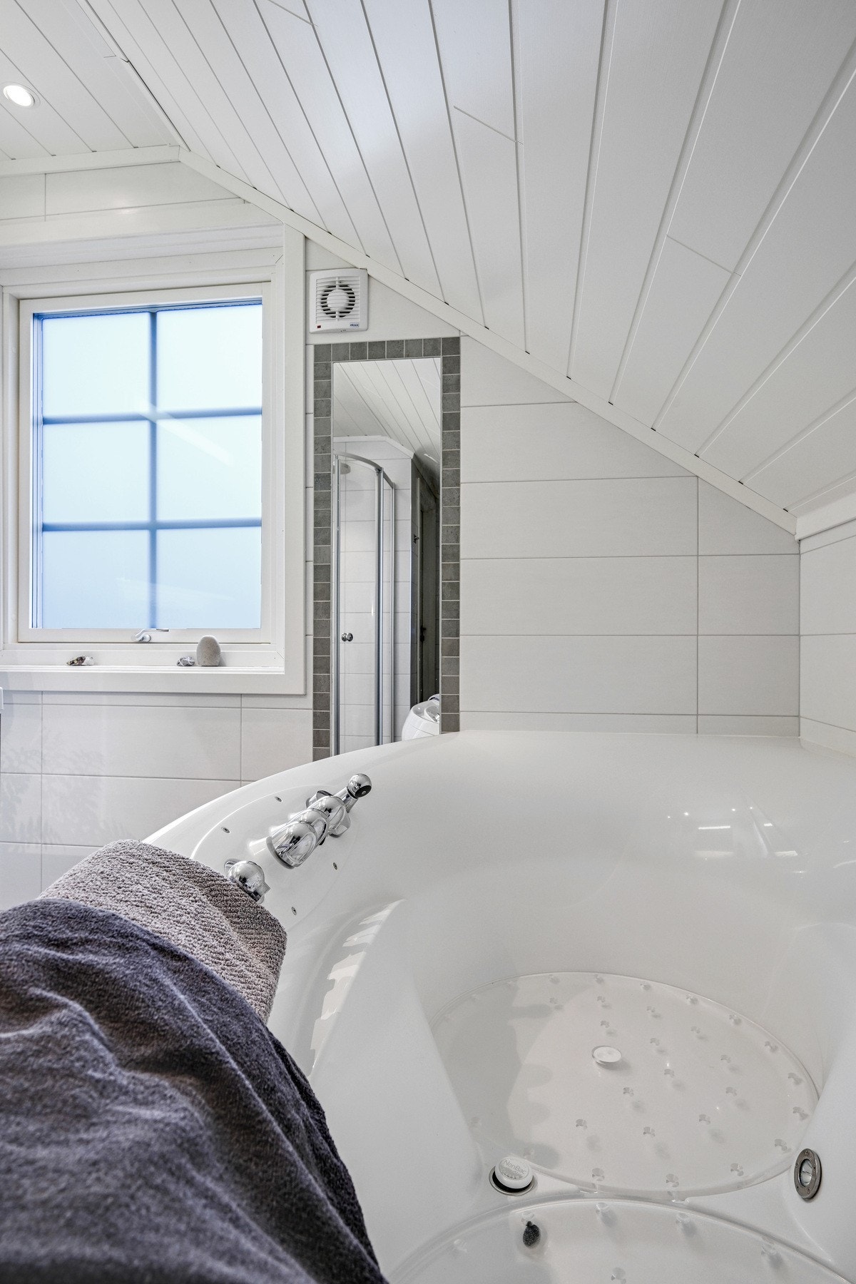 Badet er innredet med dusjhjørne, badekar, servant med innredning og vegghengt toalett. Galleribilde