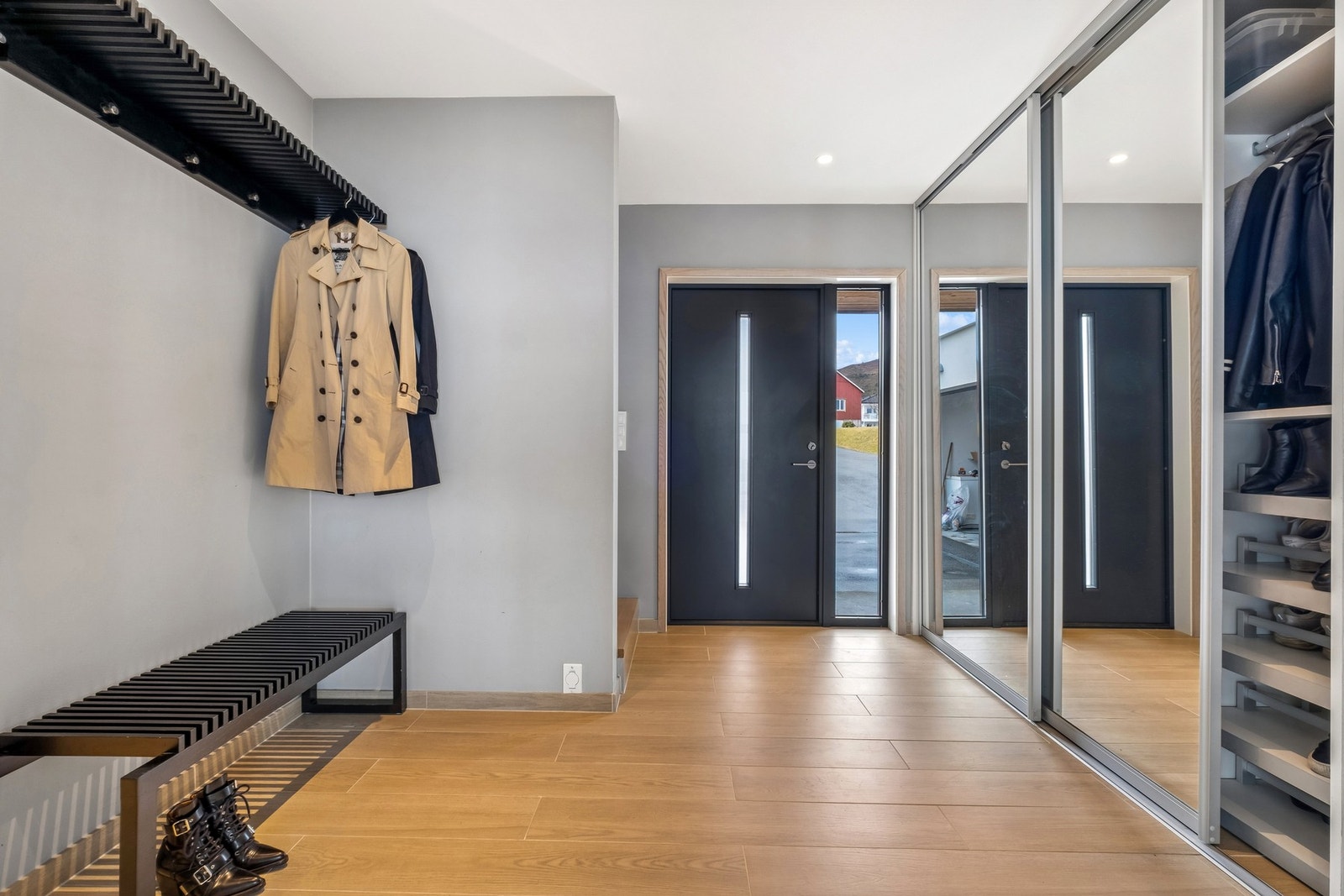 En romslig og innbydende hall møter deg ved inngangen, med skyvedørsgarderobe, sittebenk og gode oppbevaringsmuligheter som gir et ryddig og praktisk førsteinntrykk. Galleribilde