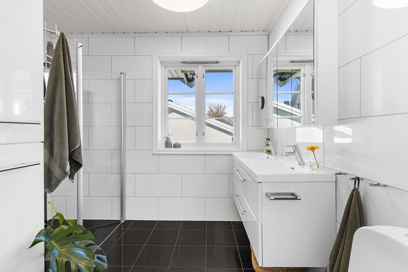 Baderom i hovedetasjen har nøytrale fliser på vegger og gulv, med varmekabler Galleribilde