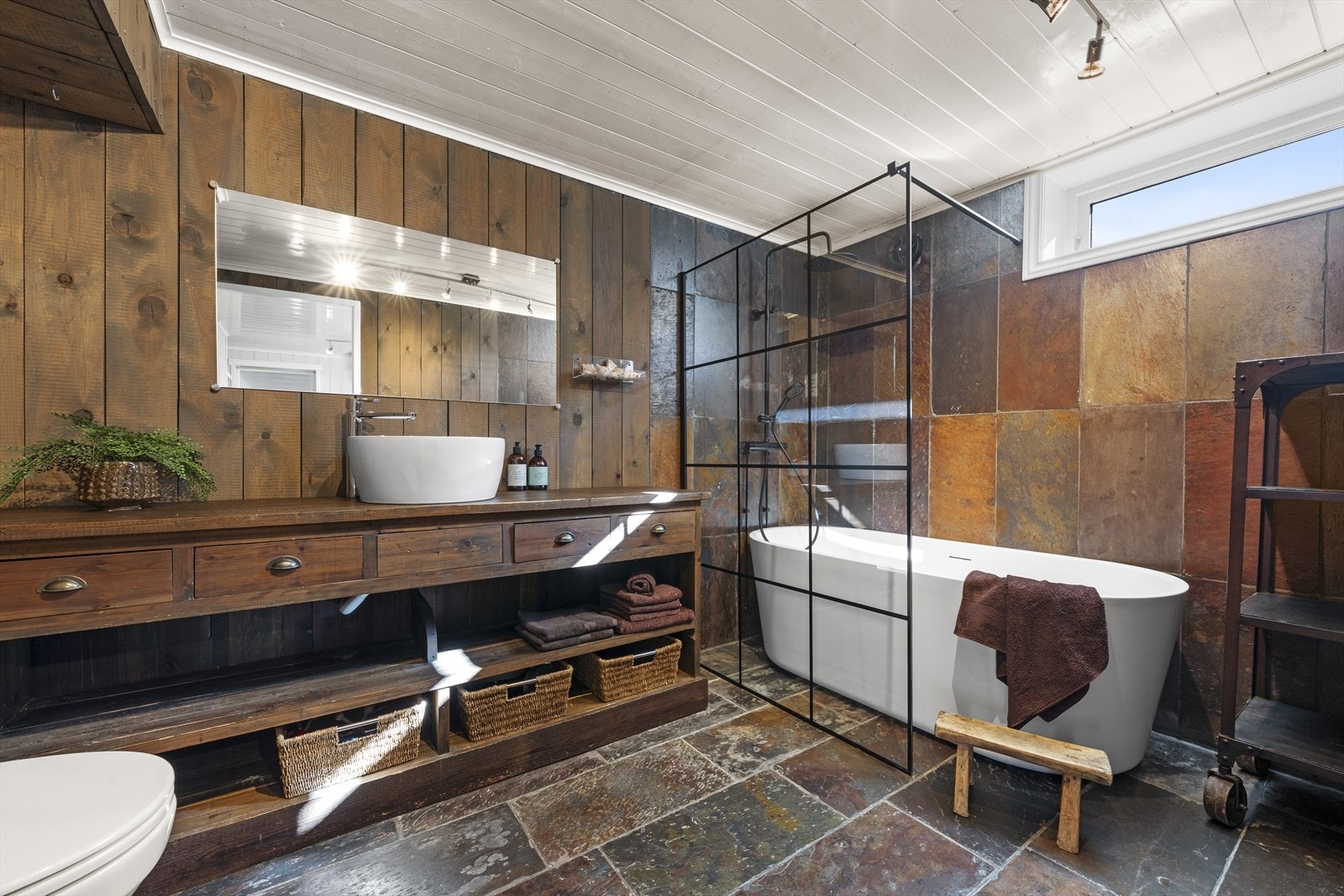 Baderommet i kjelleren er meget romslig, og har rustikke fliser på gulv, med varmekabler Galleribilde