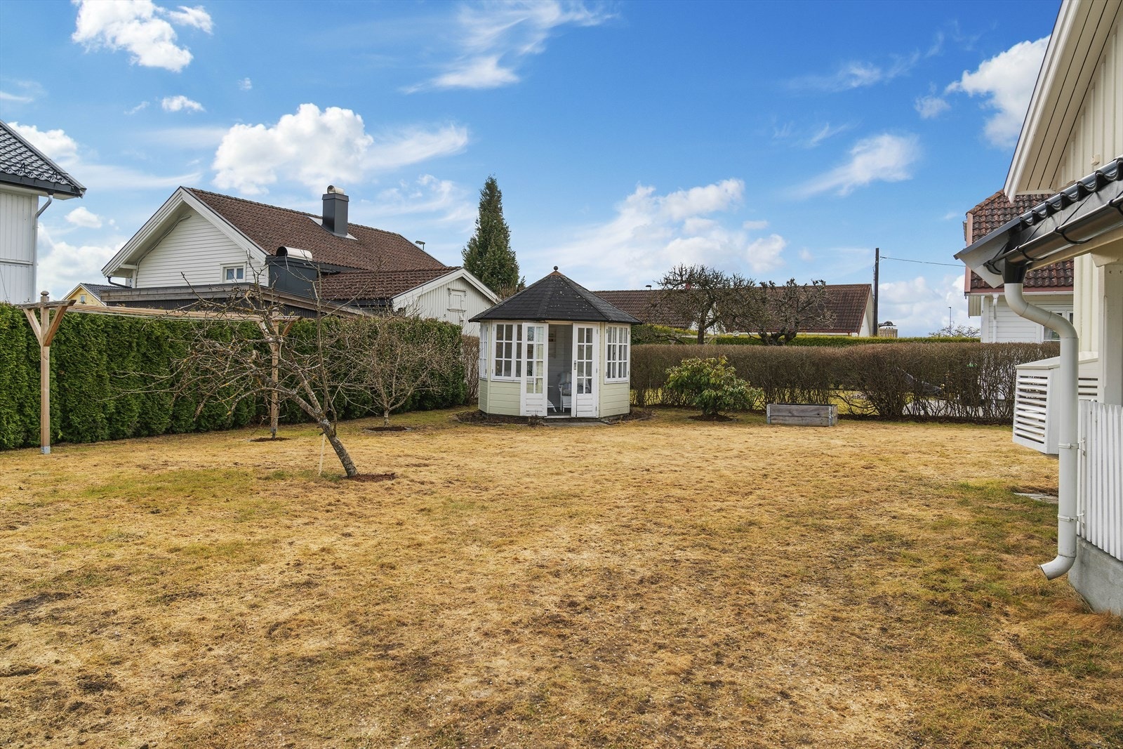 Tomten er rikt beplantet med ulike prydbusker, prydtrær, frukttrær og blomsterbed Galleribilde