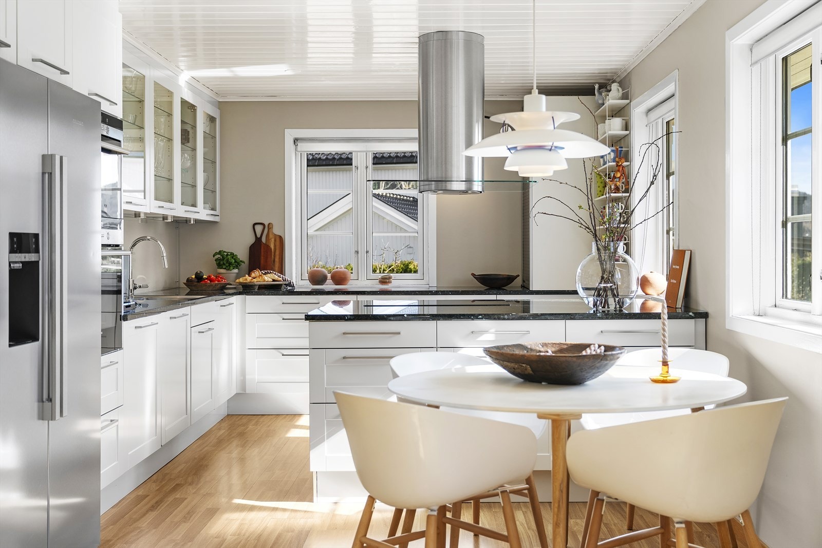 Kjøkkeninnredning fra HTH med hvite profilerte fronter og benkeplate i stein Galleribilde