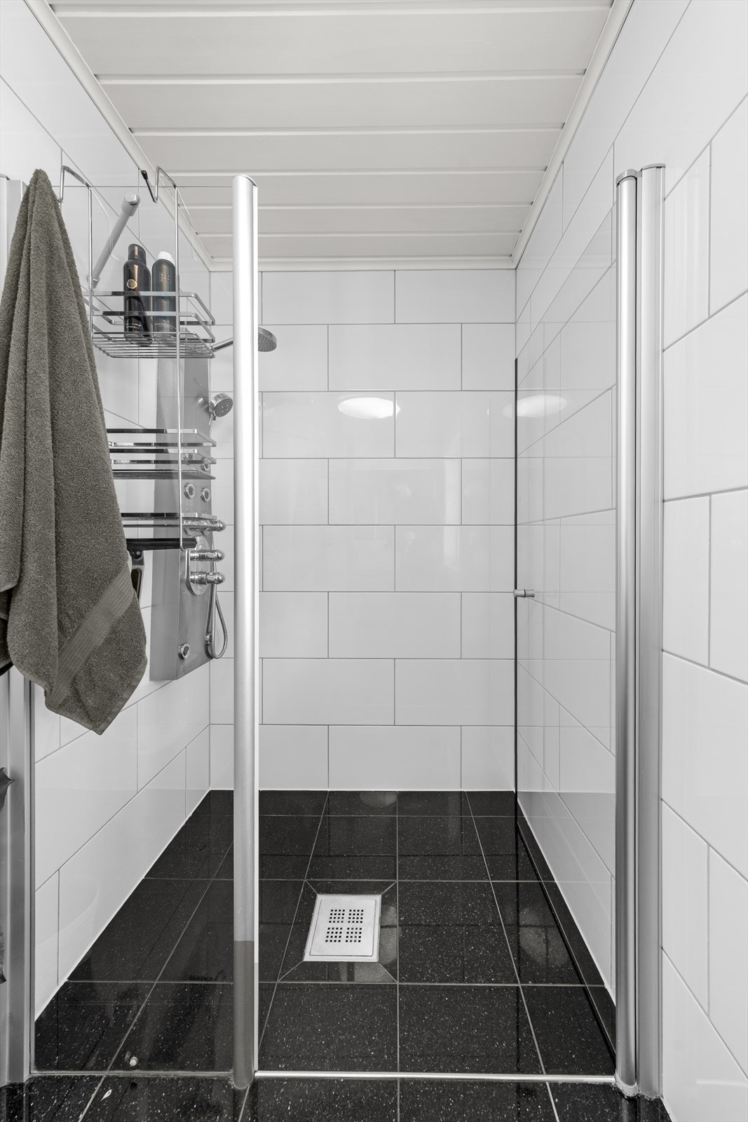 Romslig dusjnisje med dusjganrityr på vegg og innfellbar glassdør Galleribilde