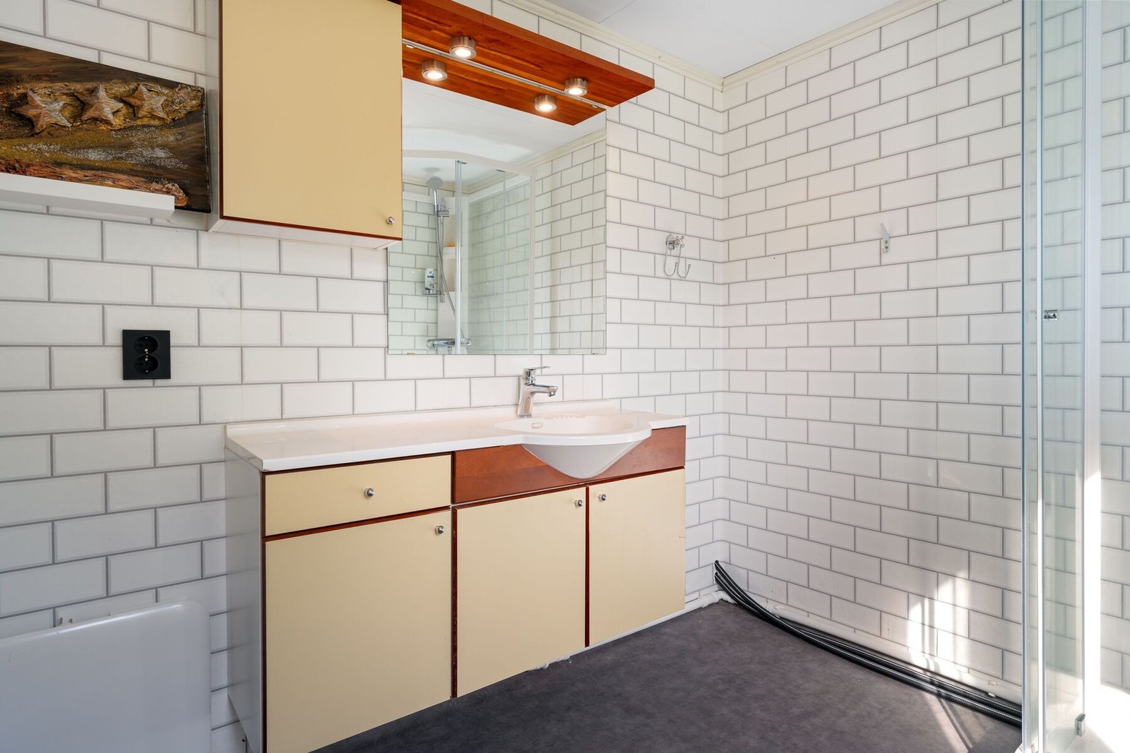 Badet er utstyrt med baderomsinnredning og dusjkabinett Galleribilde