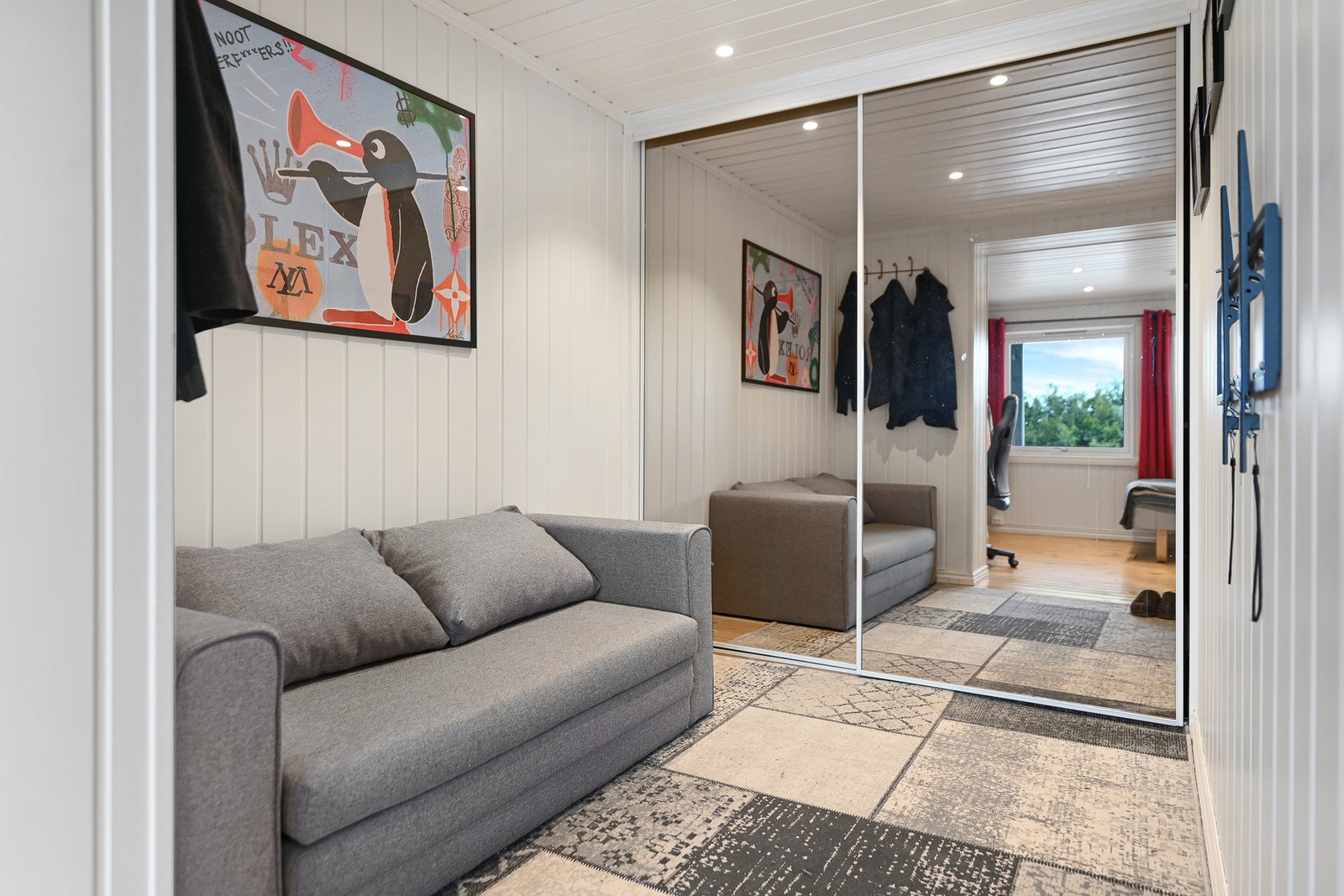 Innbydende gang med lys innredning, speilskap og utsikt mot et rom med vindu og skrivebord. Galleribilde