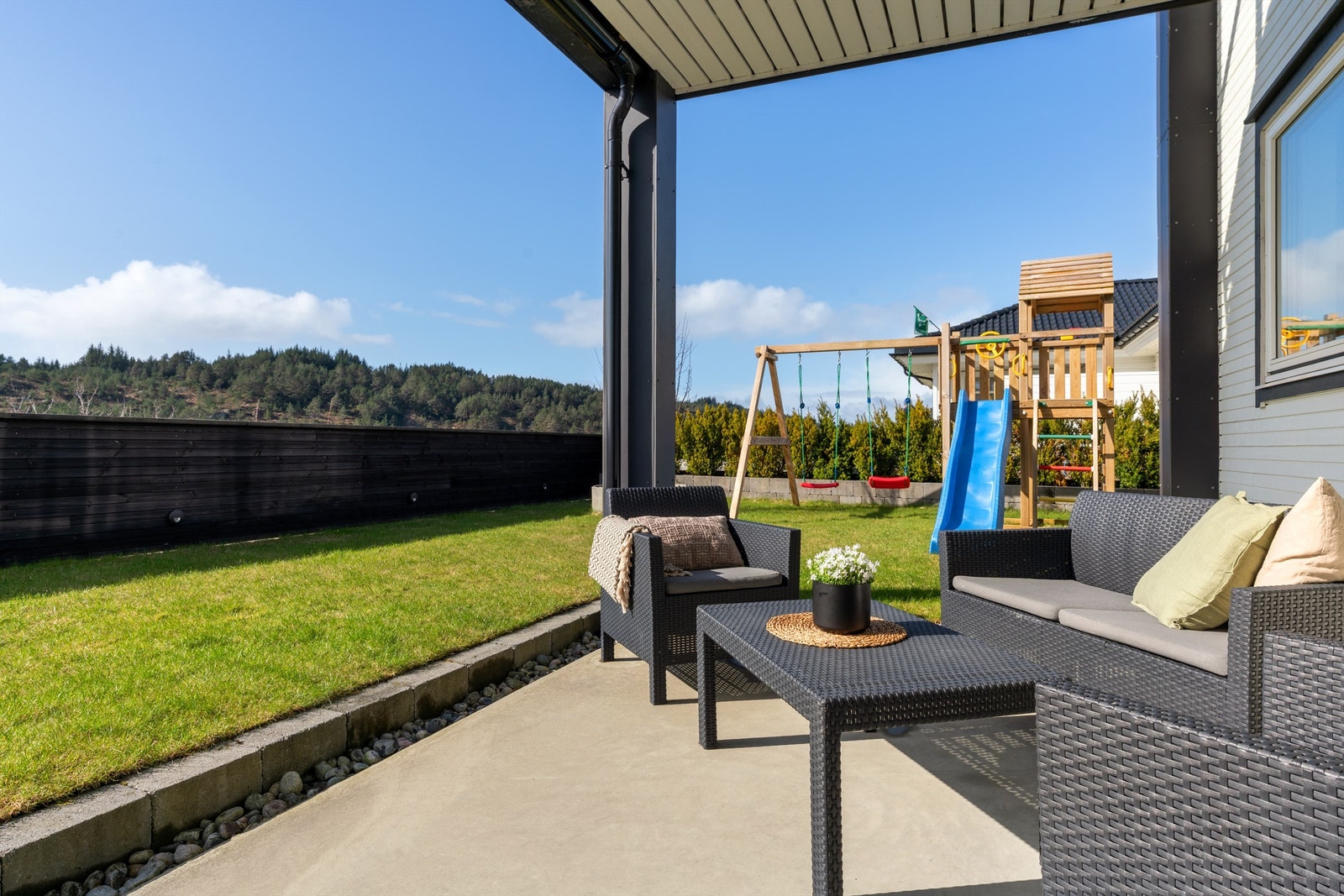 Flott hage med plen og finstøpt stor markterrasse (deler av den i dette bildet). Integrert belysning i gjerdet ved plen. Galleribilde