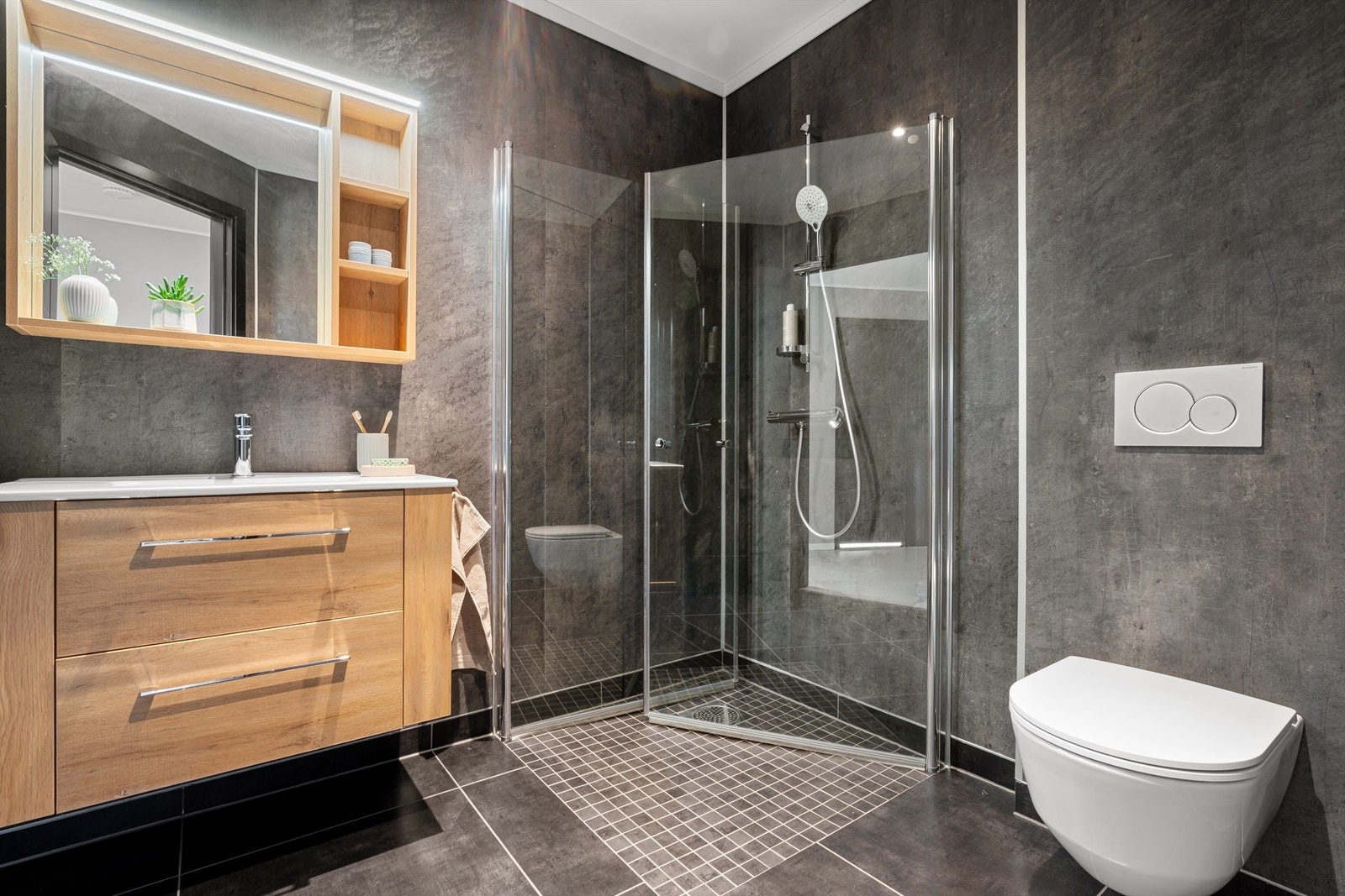 Flott bad/wc i 1 etasje med fliser på gulv og veggehengt toalett. Galleribilde