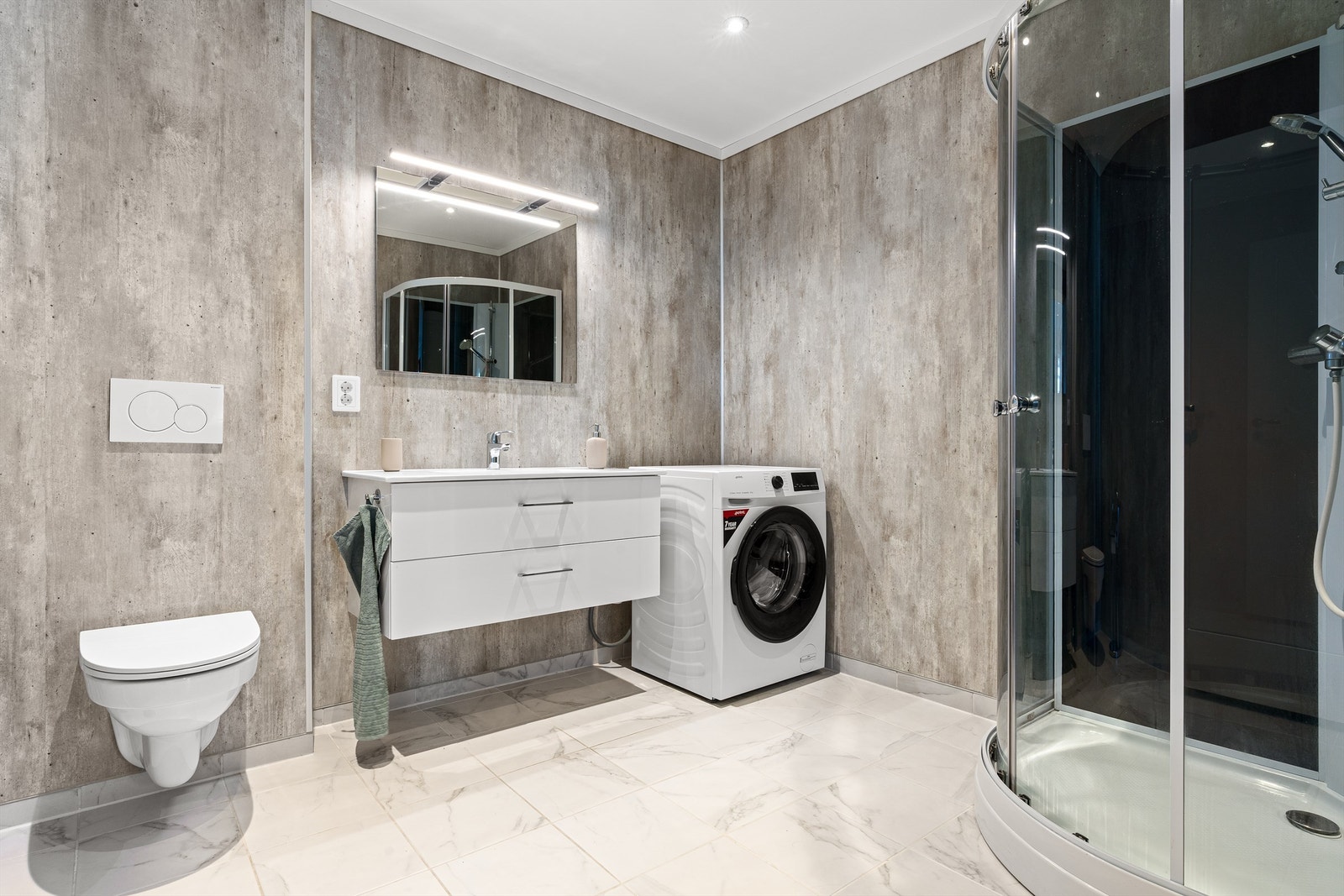 Hybelleilighet: Bad/wc kombinert vaskerom. Moderne og meget pent bad/wc med spotter i tak og vegghengt toalett. Galleribilde