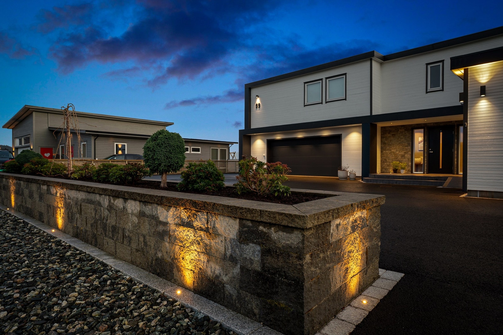 Nydelig mur med integrert bed som deler eiendommen fra tilkomstveien. Nydelig belysning rundt murkanten. Galleribilde