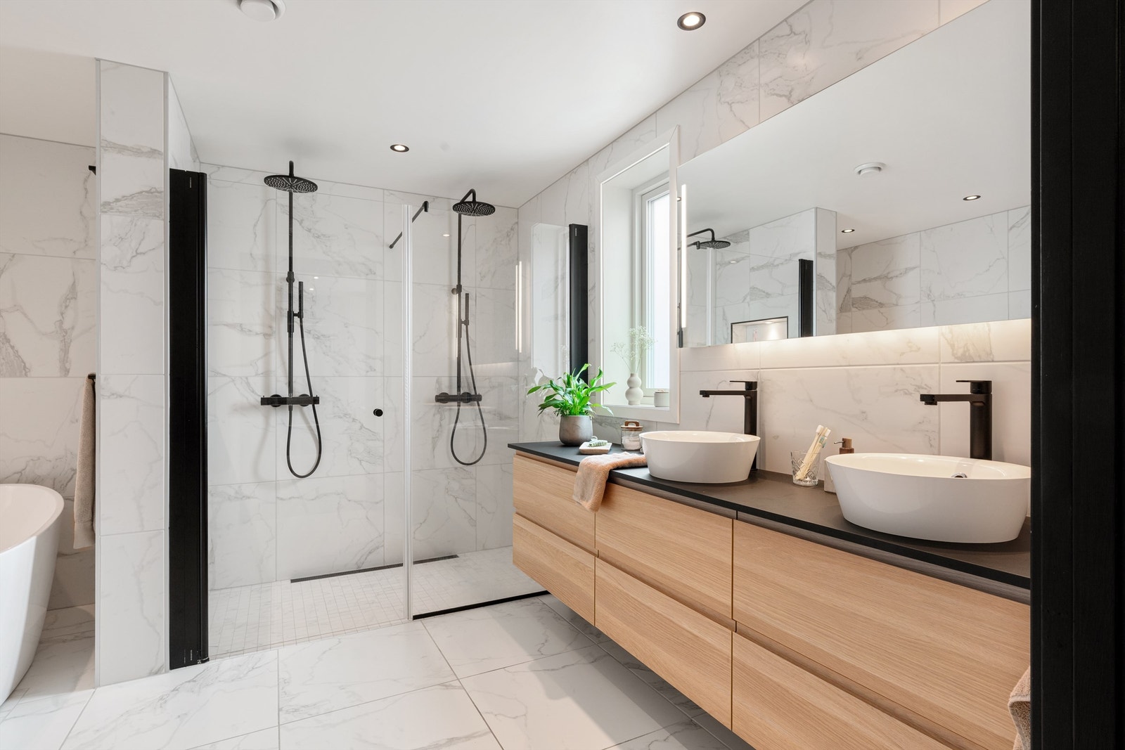 Stort baderomsmøbel med to servanter og speil med integrert belysning. Helfliset lekkert og stort baderom. Galleribilde