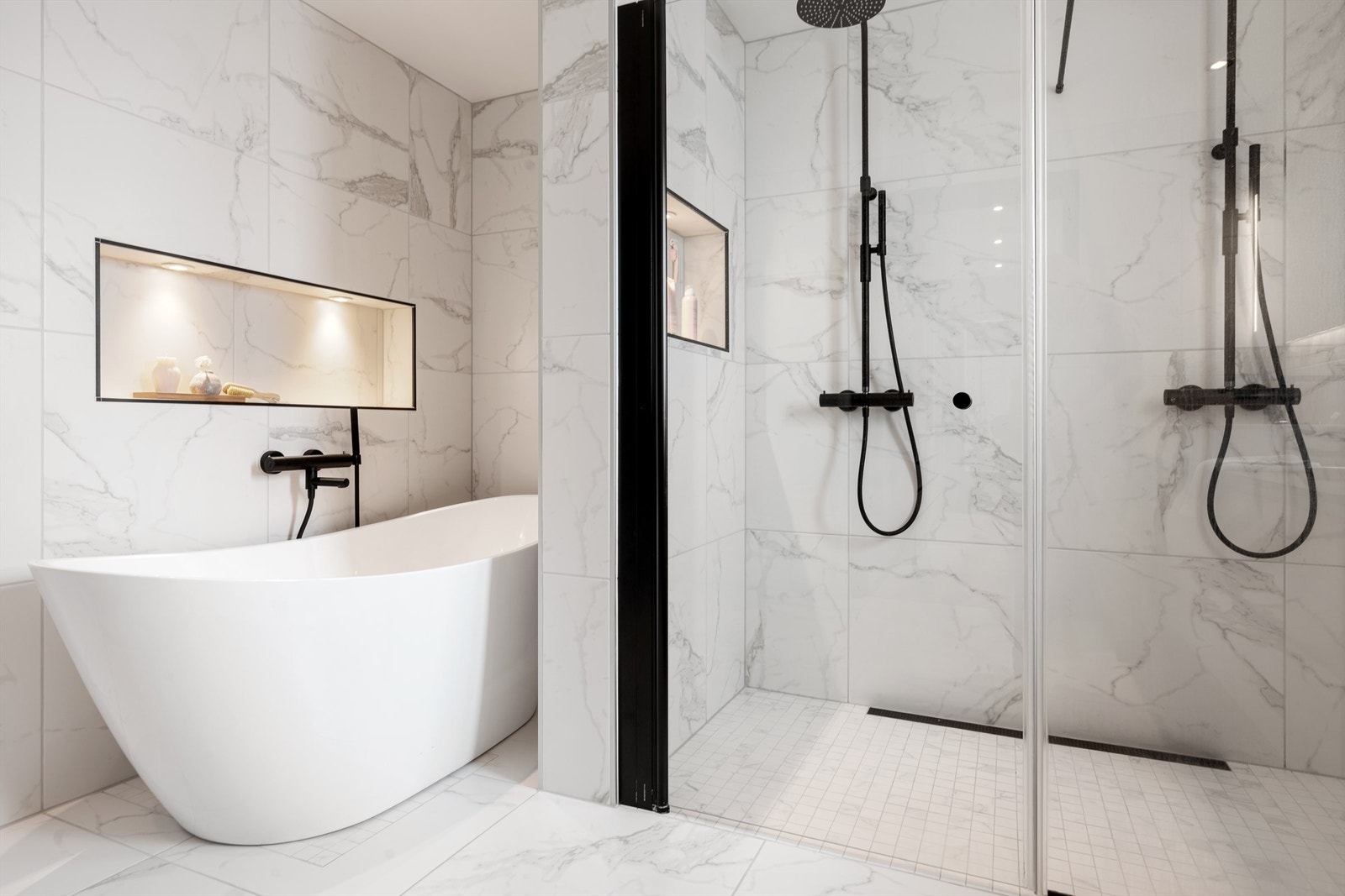 Integrert hylle med belysning også i dusjsonen. Unidrain sluk med slukrist mot vegg i gulv. Matchende mosaikkfliser på gulv i dusjsone. Galleribilde