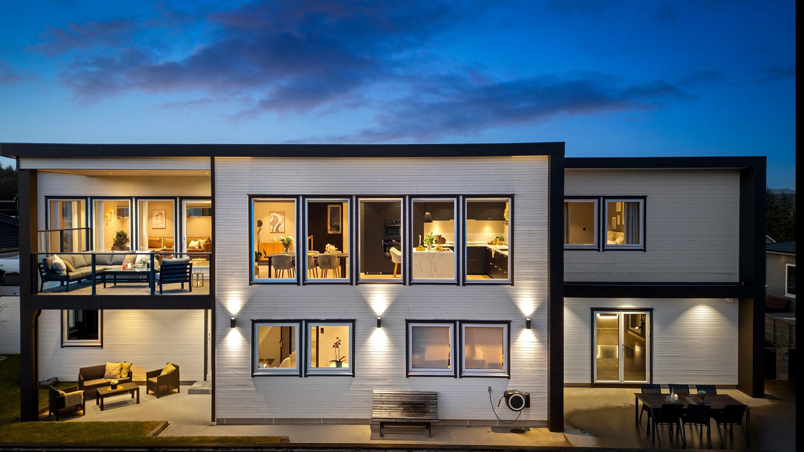 Stor flott markterrasse i finstøpt betongdekke langs store deler av husets fasade mot vest. Galleribilde