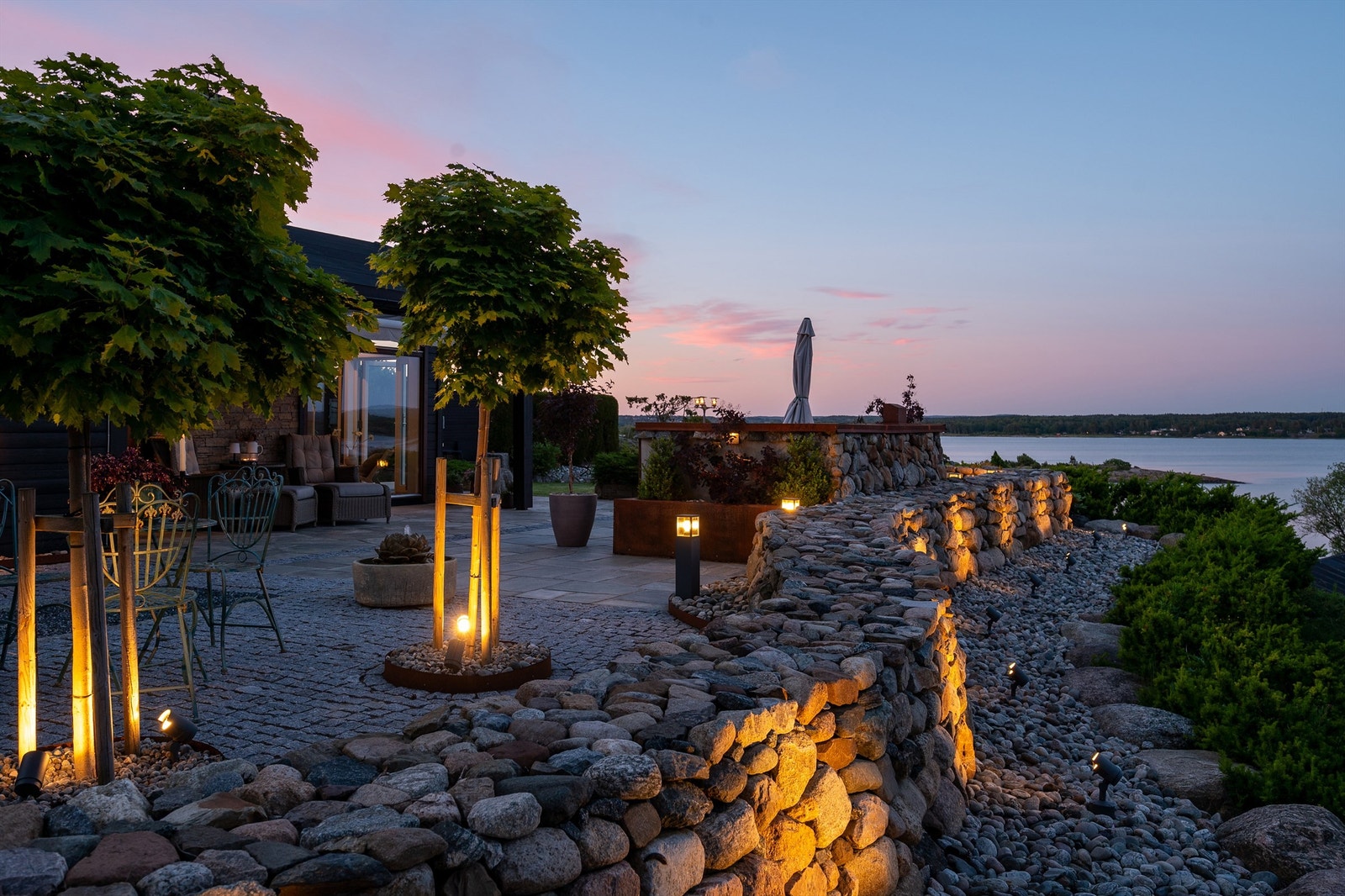 Bølgende mur og runde kulesteiner i myk kontrast til plattingens glatte flater og snorrette linjer. Galleribilde
