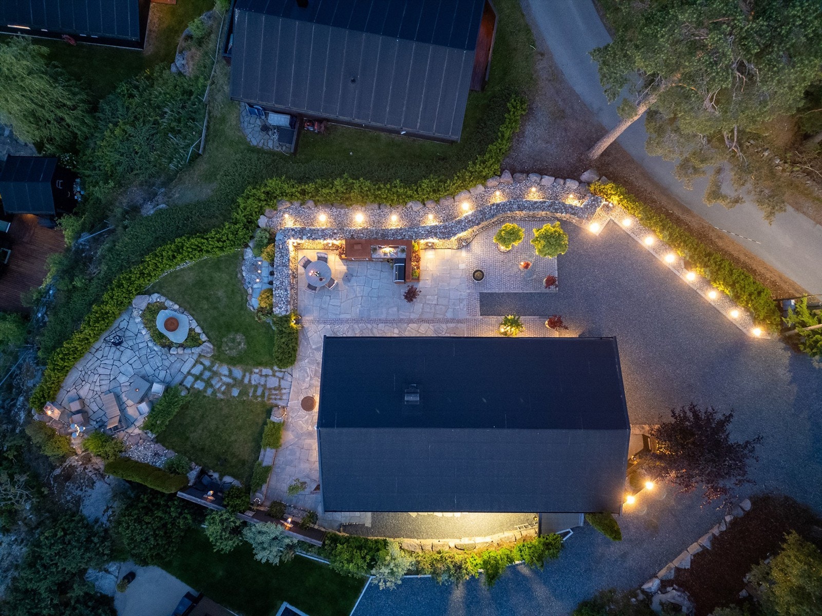 Effektfull lyssetting fremhever så vel hytta som særtrekkene ved de innbydende utearealene. Galleribilde