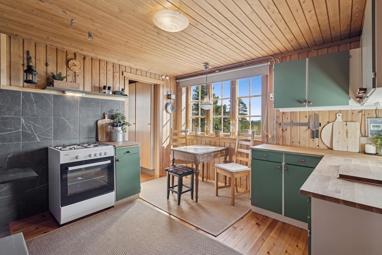 Kjøkkenet har gode løsninger for matlaging. Spiseplass ved vinduet har utsikt over naturskjønne områder med både vann og myrområder. Galleribilde