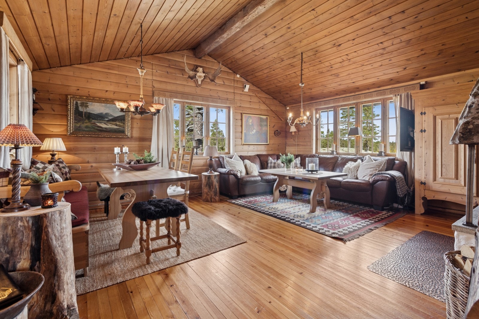Den koselige stuen har en unik atmosfære med både åpen himling som gir god romfølelse og en lunhet med sine tømmervegger Galleribilde