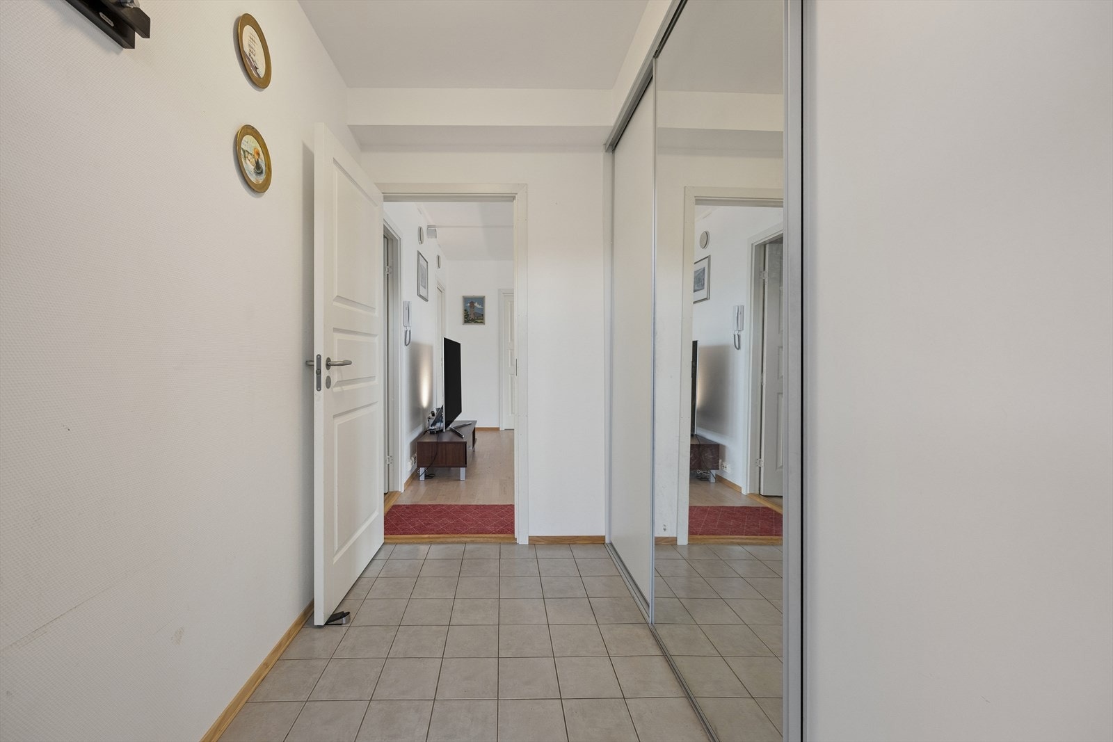 Entréen ønsker deg velkommen inn og har god plass til oppbevaring i en praktisk skyvedørsgarderobe. Galleribilde