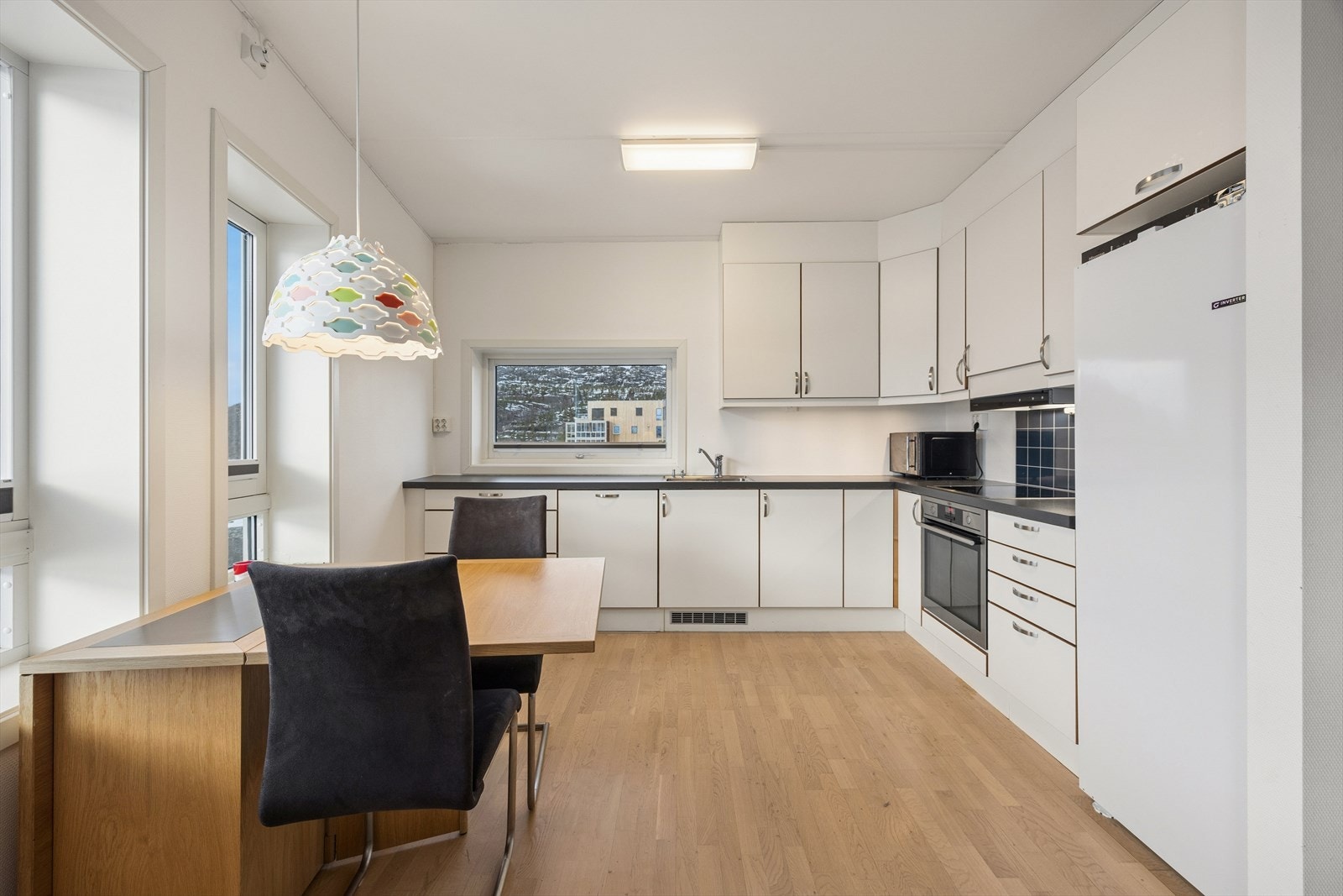 Kjøkkenet har en lys innredning med glatte fronter og en laminert benkeplate. Galleribilde