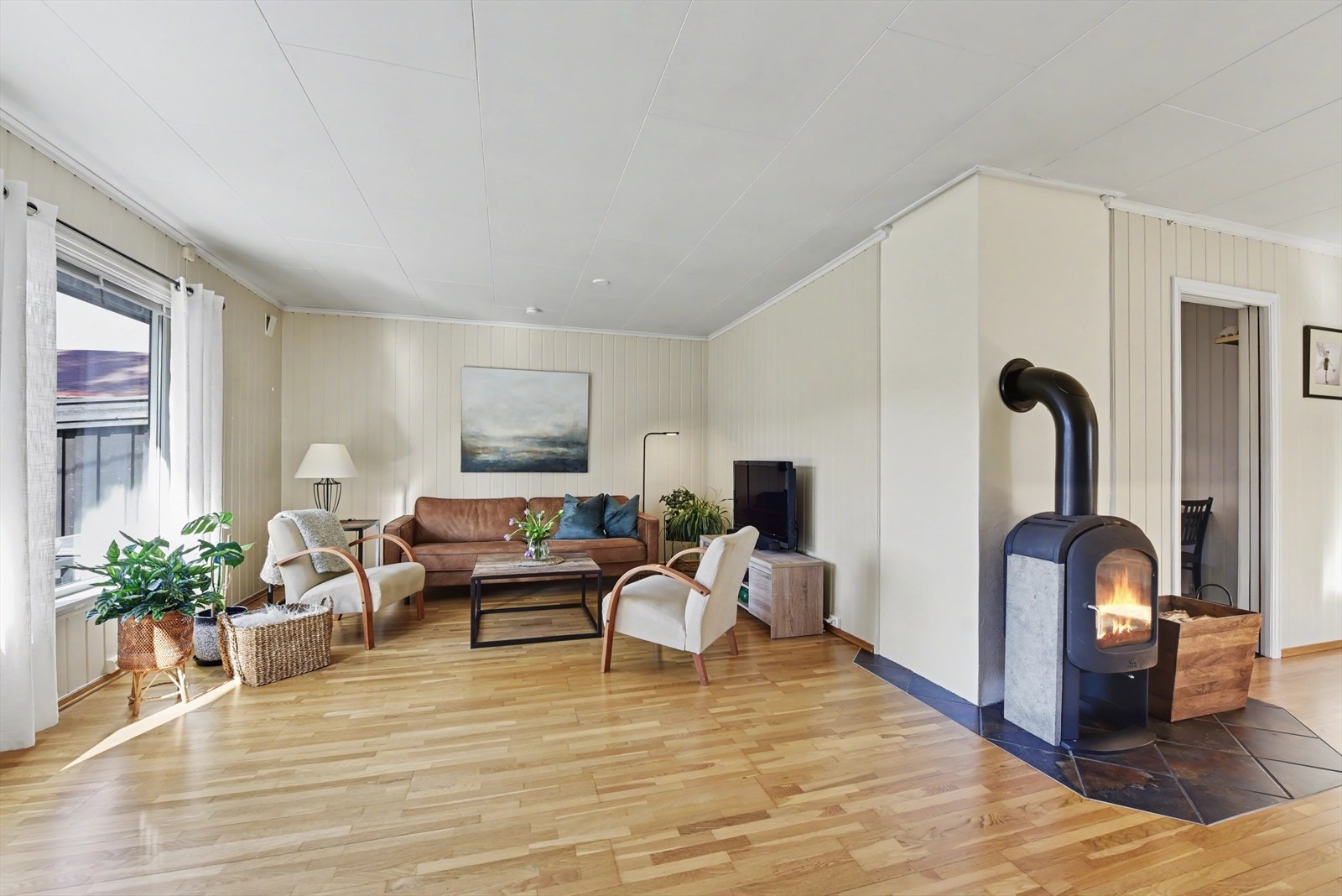 Stuen er et lunt samlingspunkt, med en peisovn installert i 2006 som gir god varme. Galleribilde