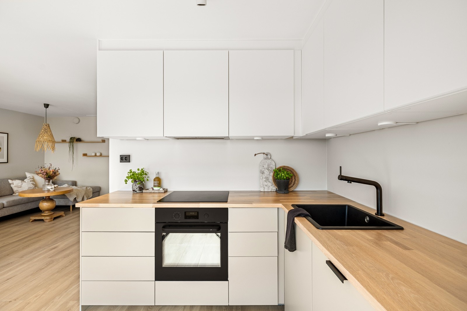 Innredningen fra Ikea har lyse, glatte fronter, takoppforede skap og benkeplate i heltre eik med nedfelt, sort kum Galleribilde