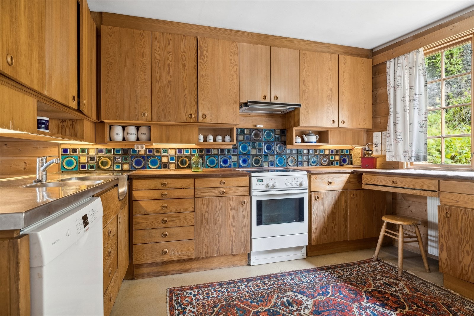 Eldre plassbygd kjøkken, med alt man måtte trenge av skap-, skuff- og benkeplass. Galleribilde