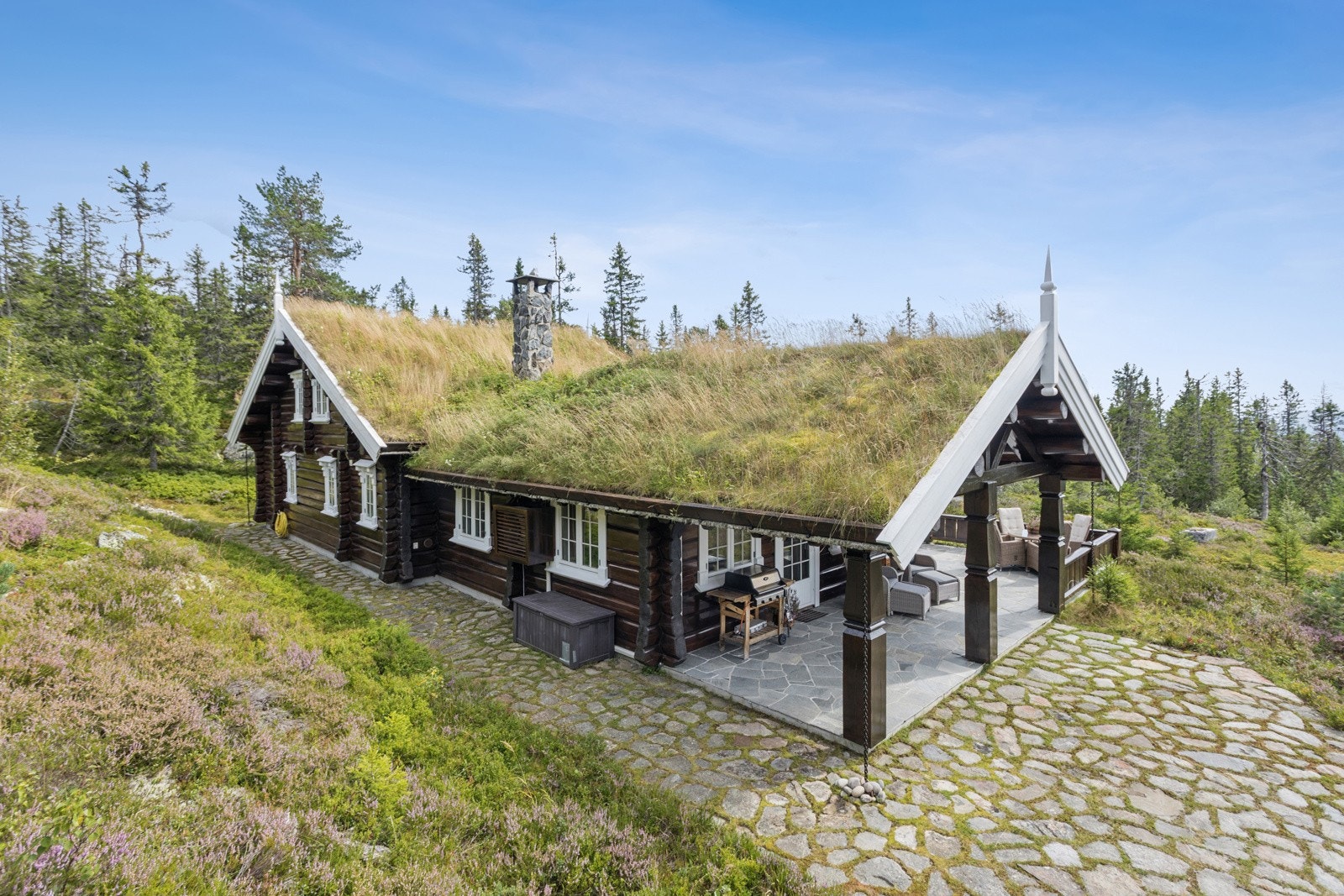 Rundt hytta er det steinbelagt uteområde og sti som gir et pent inntrykk og fine områder for utemøbler Galleribilde