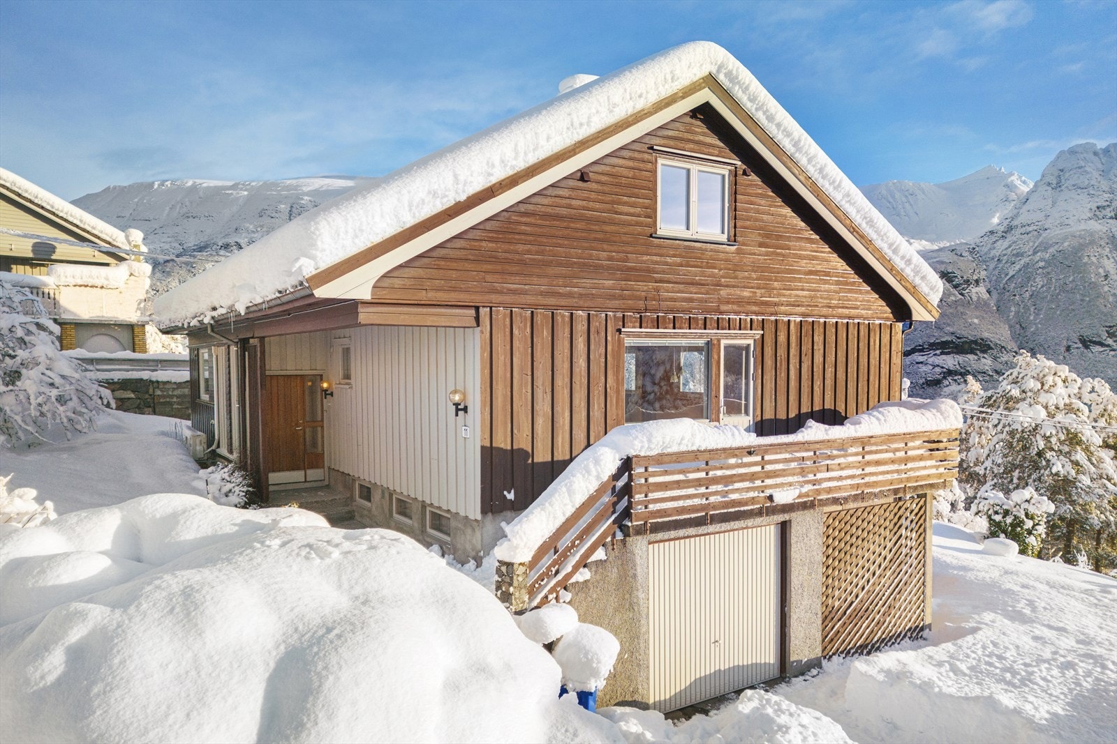 Inngangspartiet har en betongtrapp fra garasjen og parkeringsplassen opp til inngangspartiet og verandaen. Galleribilde